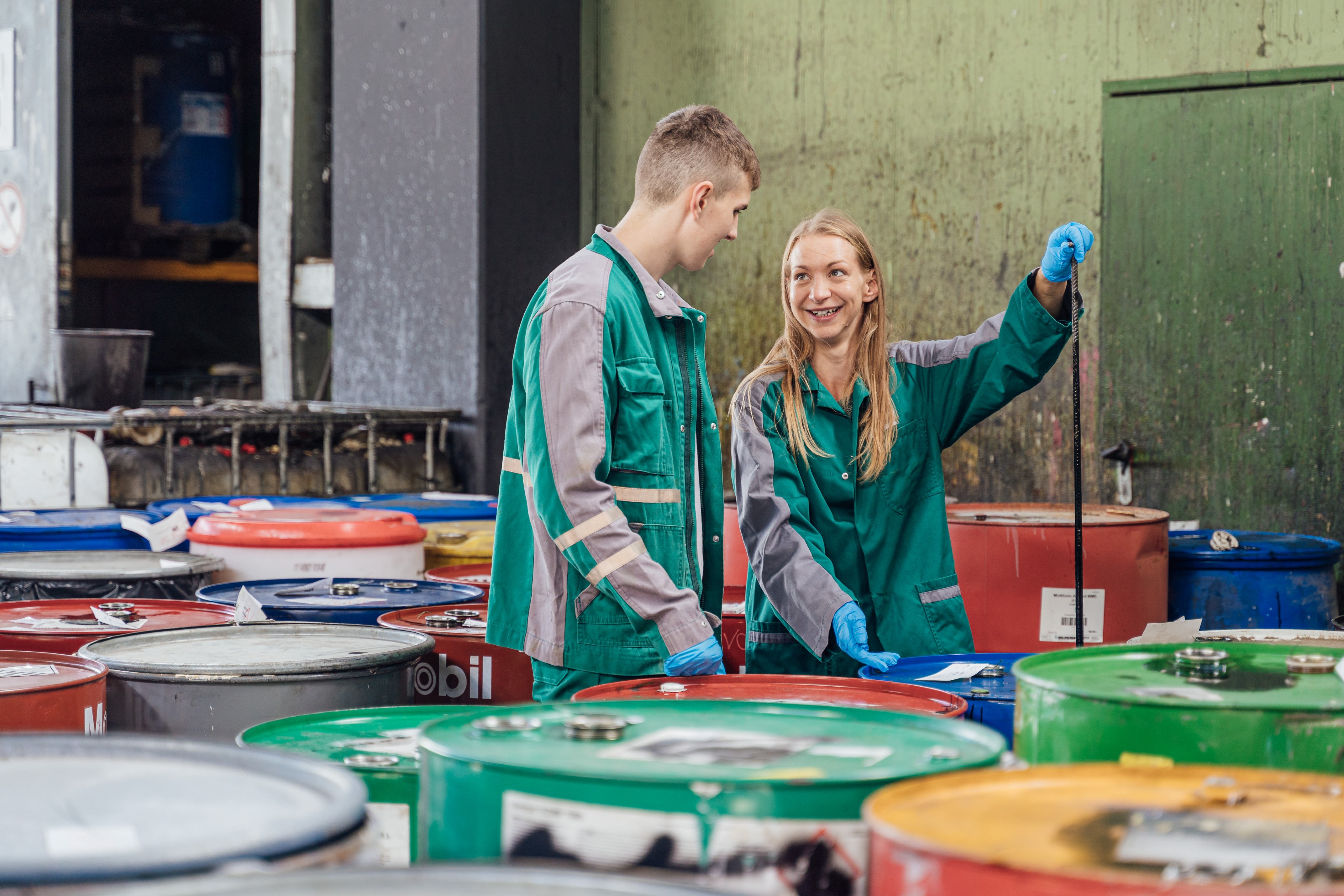 Zwei Personen umgeben von bunten Tonnen