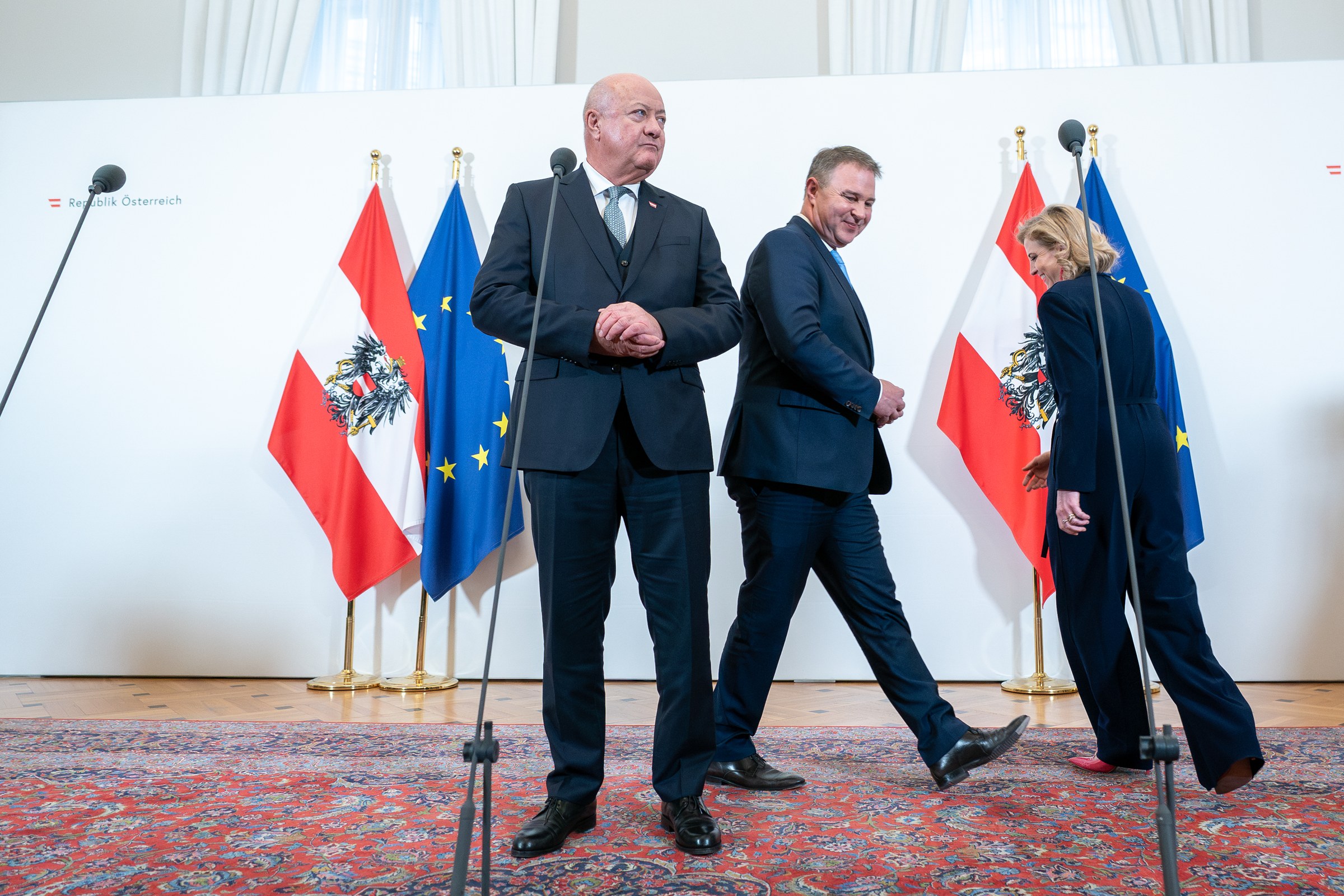 Bundeskanzler Christian Stocker, Vizekanzler Andreas Babler und Au&szlig;enministerin Beate Meinl-Reisinger suchen ihren Platz bei einem Doorstep im Bundeskanzleramt.