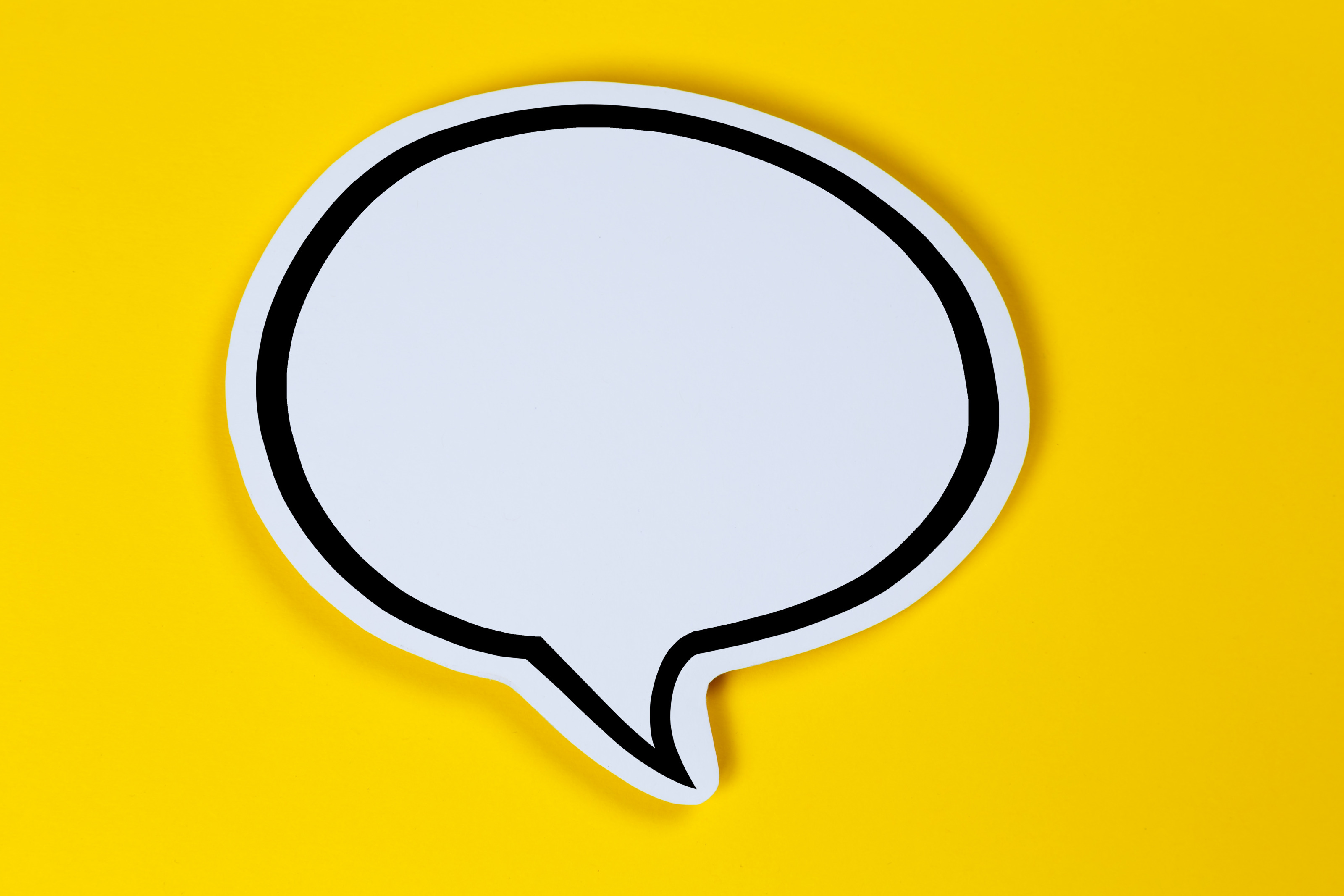 Weiße Sprechblase mit schwarzer Umrandung auf gelbem Hintergrund