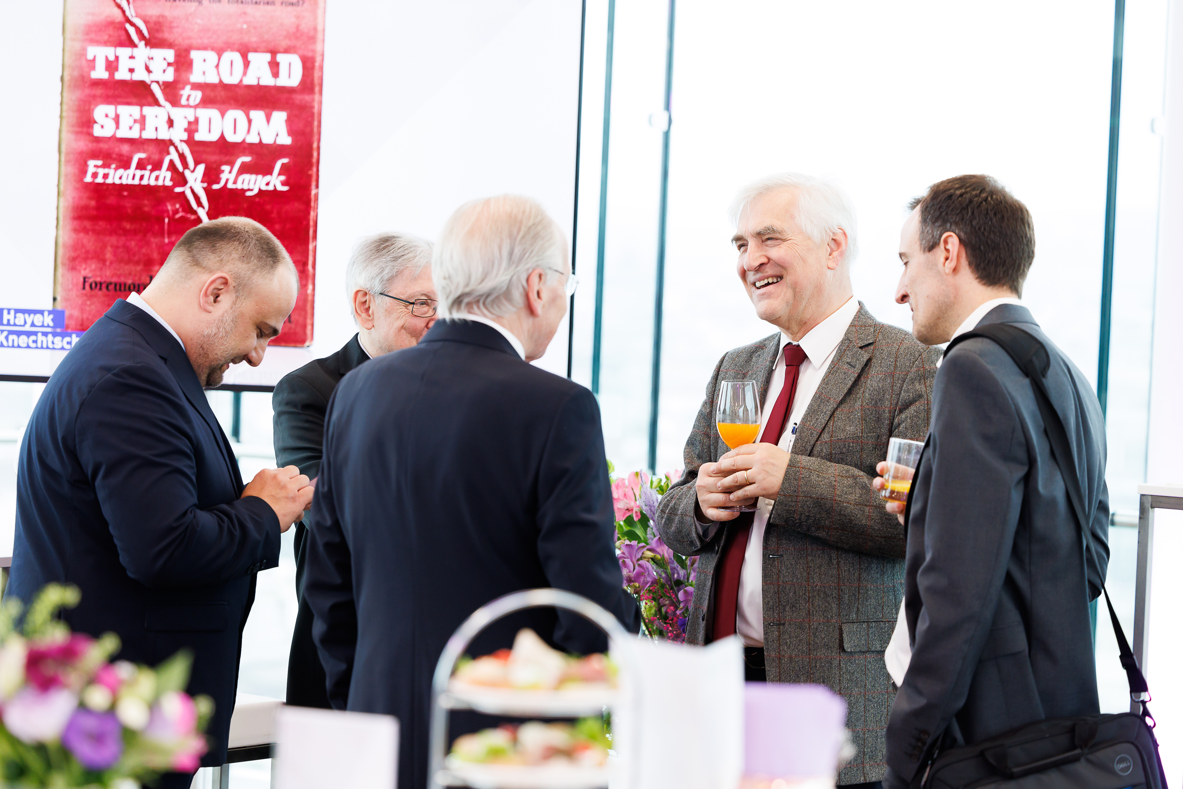 Eine Gruppe schick gekleideter Personen steht gemeinsam und lacht