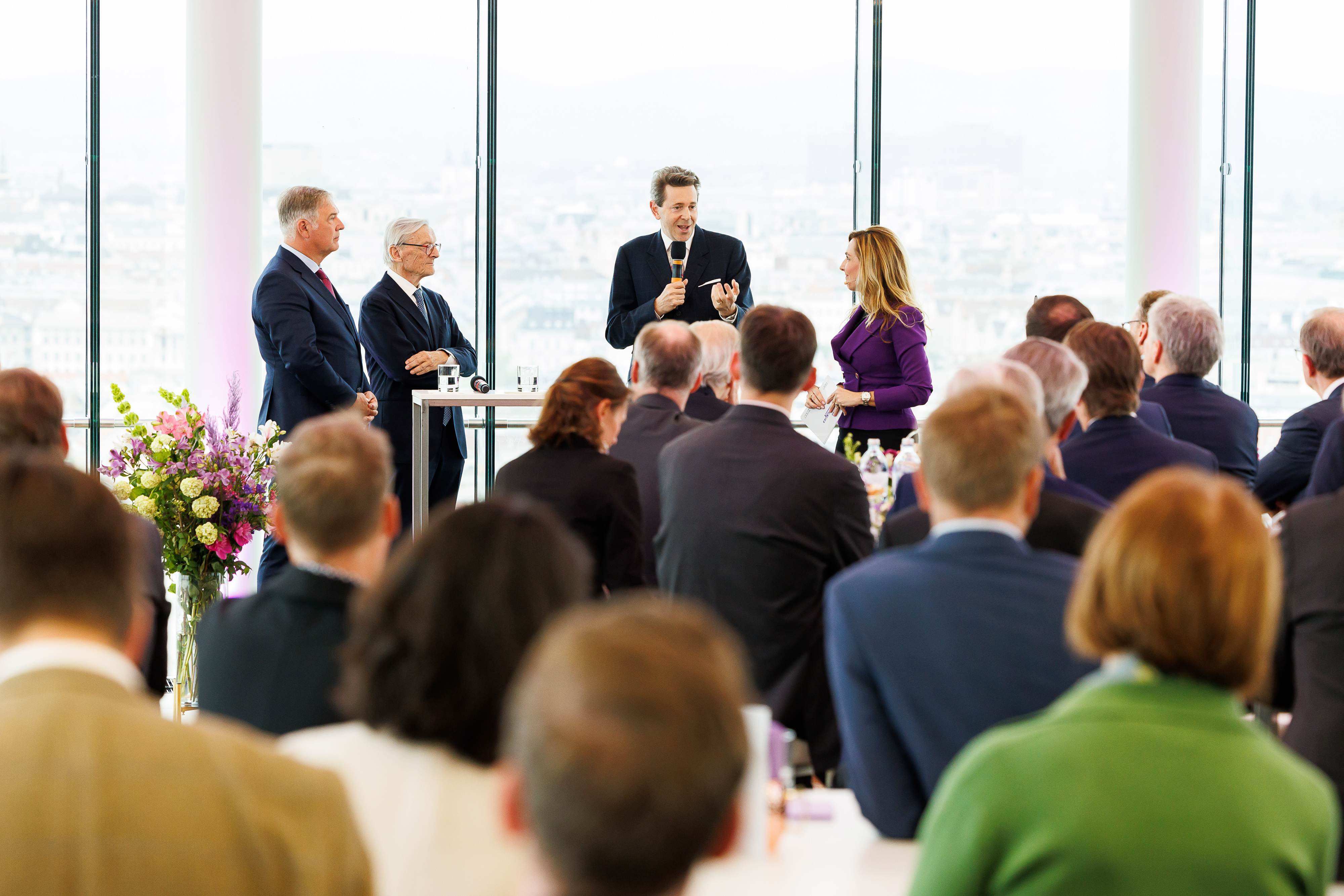 schick gekleidete Personen sprechen zum Publikum