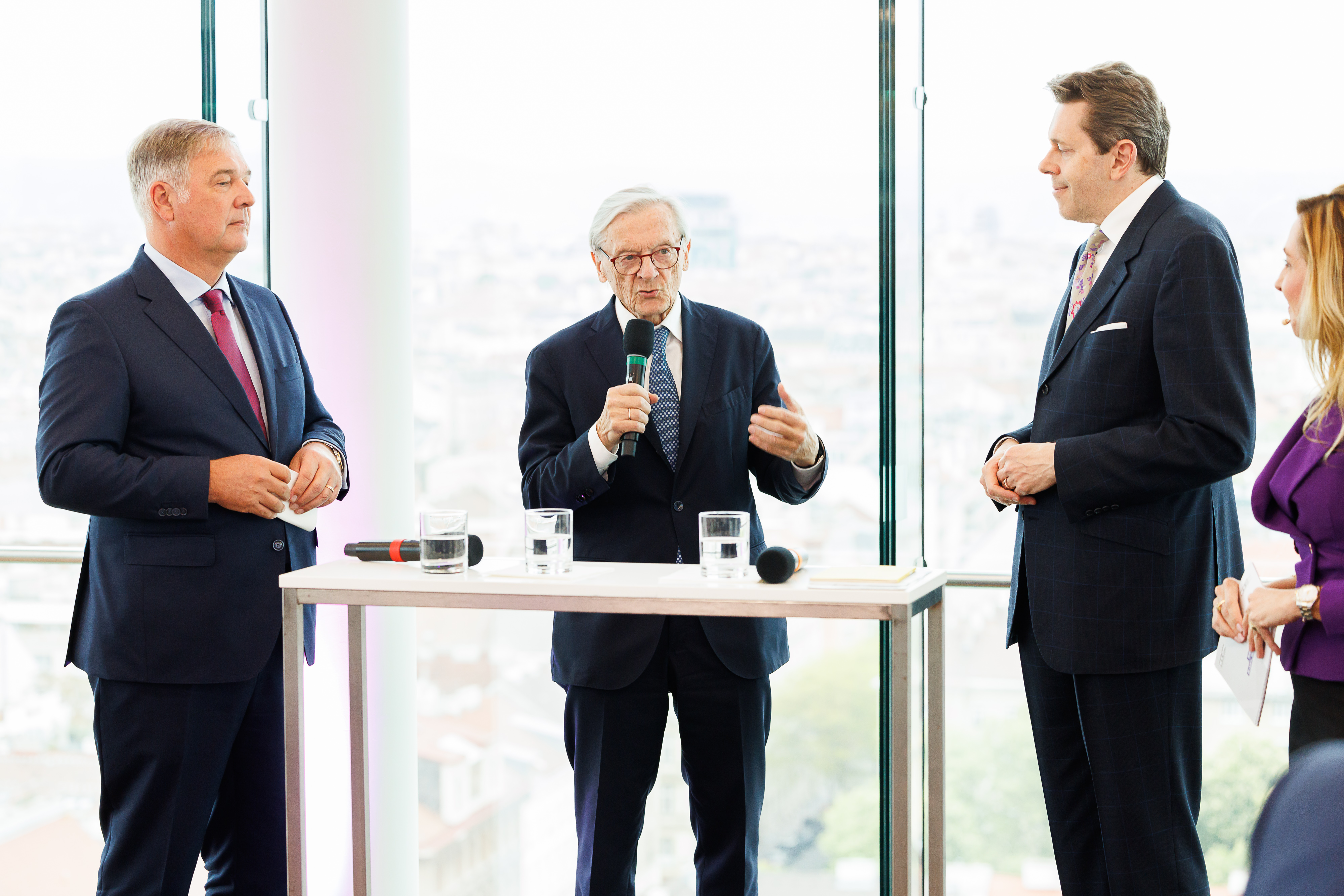 Personen im Anzug sprechen vor dem Publikum