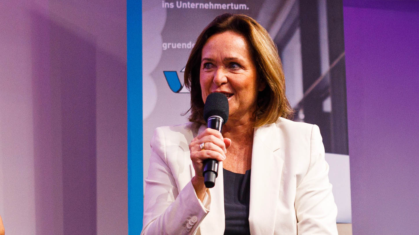 Angelika Sery-Froschauer mit Mikrofon am Podium