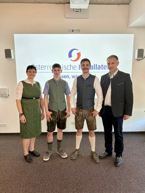 Vier Personen vor Projektionsfl&auml;che mit Logo der &Ouml;sterreichischen Installateure.