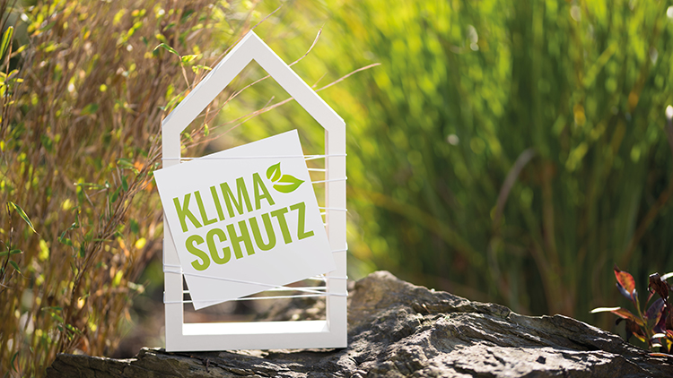 Holzh&auml;uschen mit Aufschrift Klimaschutz in Natur stehend