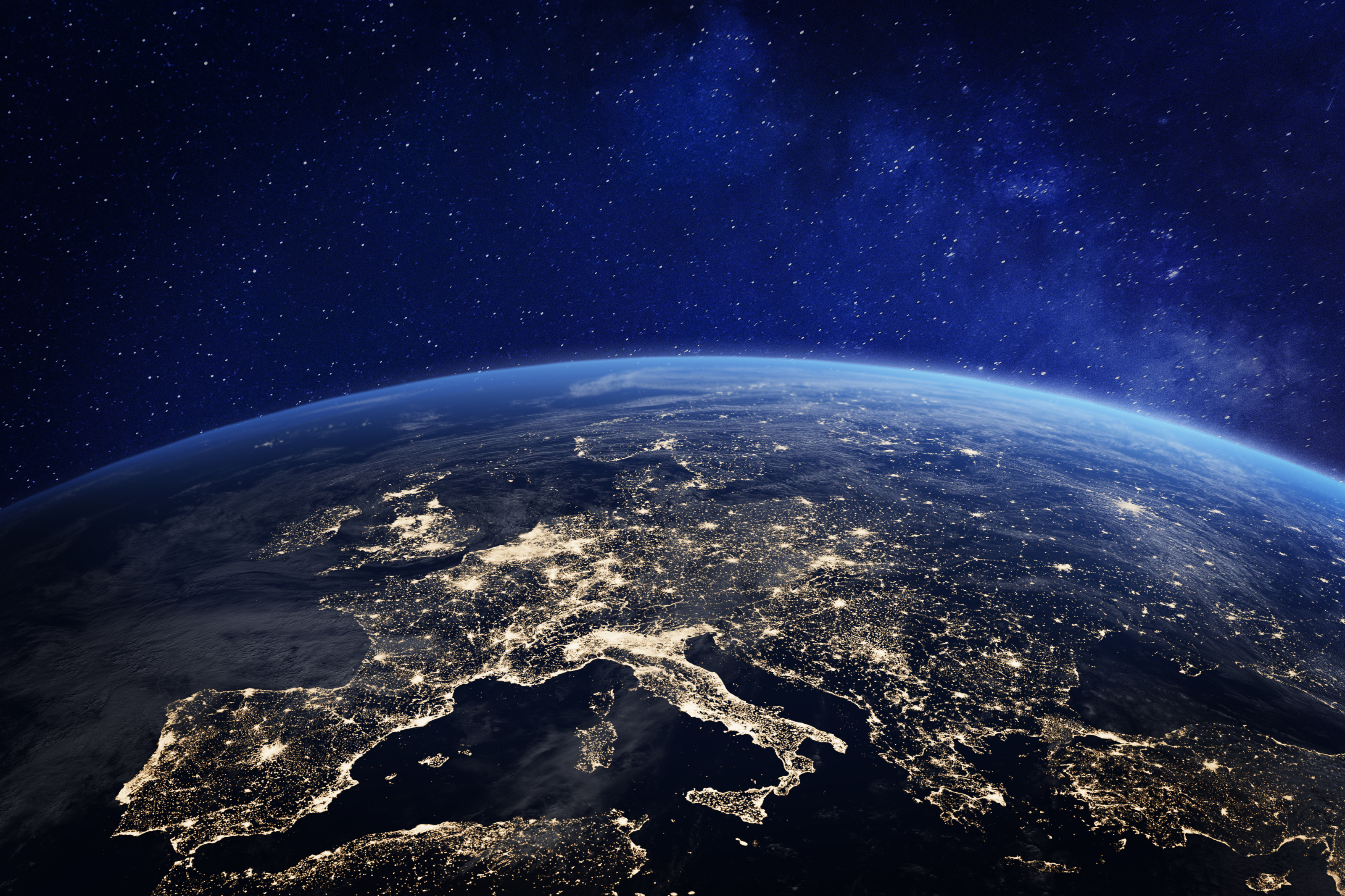 Satellitenaufnahme Europas bei Nacht mit vielen hellen Punkten, W&ouml;lbung der Erde ersichtlich