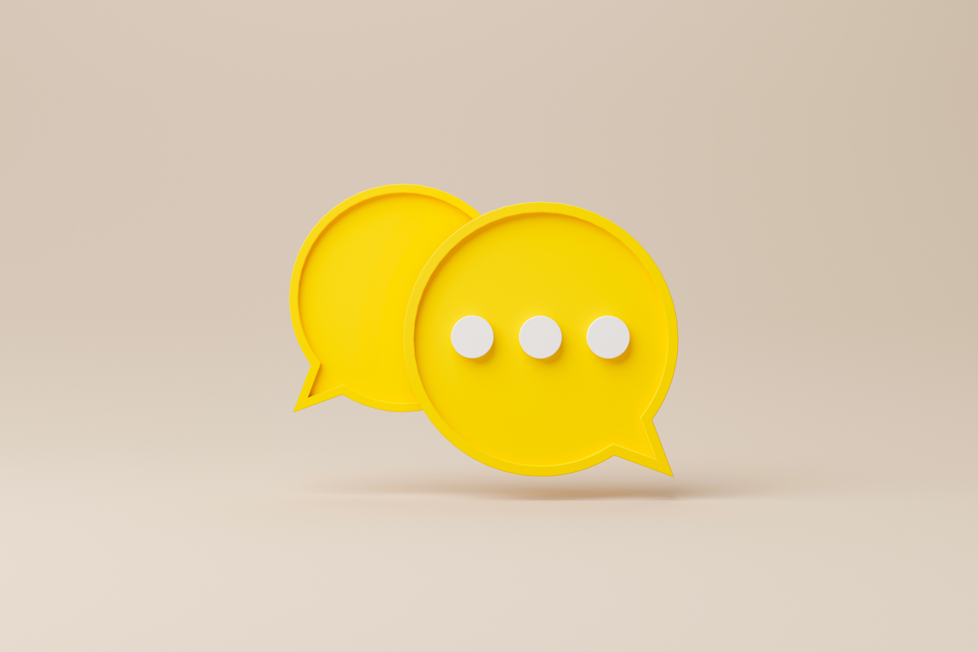 Grafische Darstellung zweier gelber Sprechblasen, in einer drei wei&szlig;e Punkte