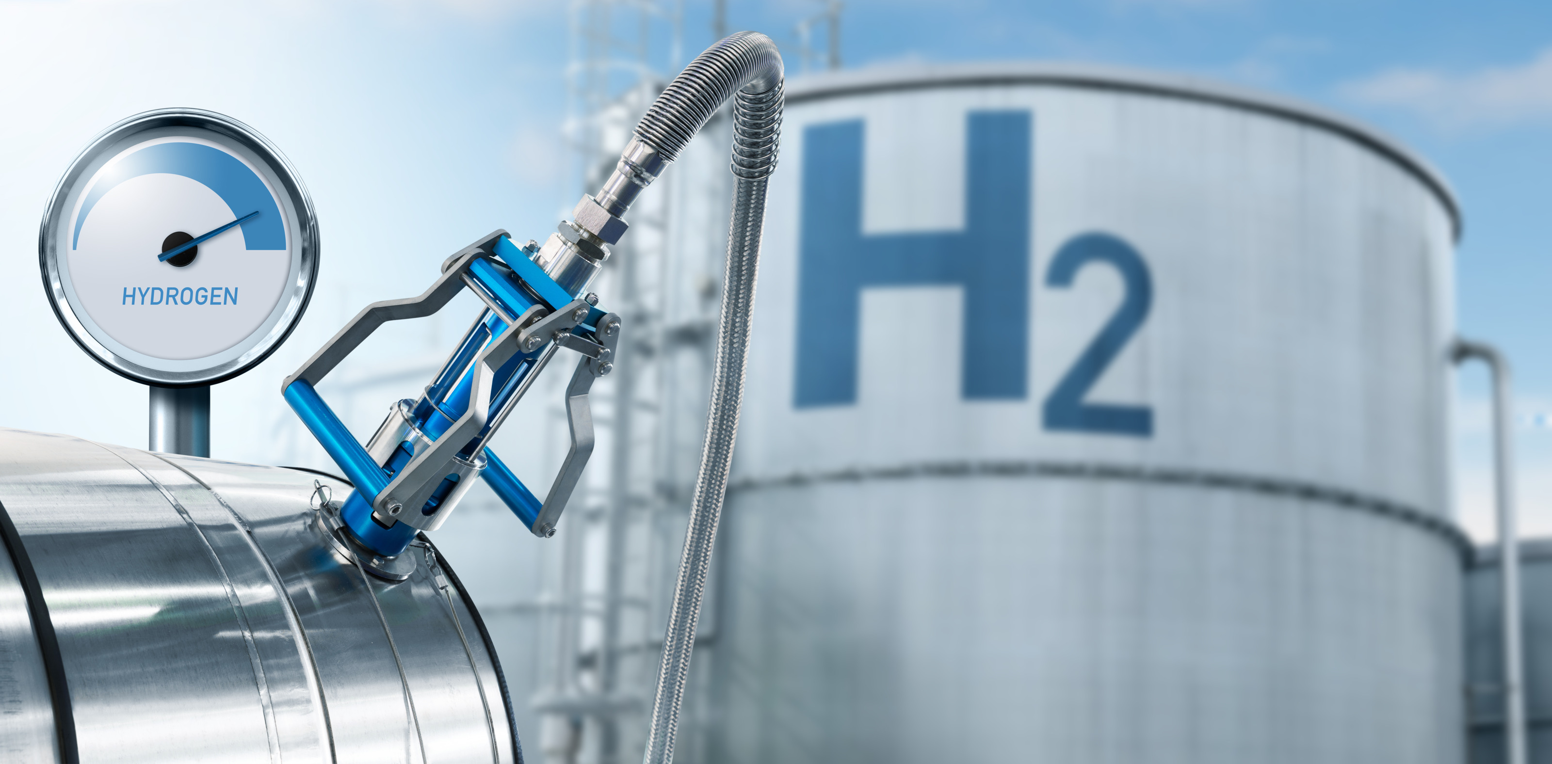 Fokus auf Zapfhahn einer Wasserstoffanlage mit Druckanzeige, im Hintergrund gro&szlig;er Container mit Beschriftung H2