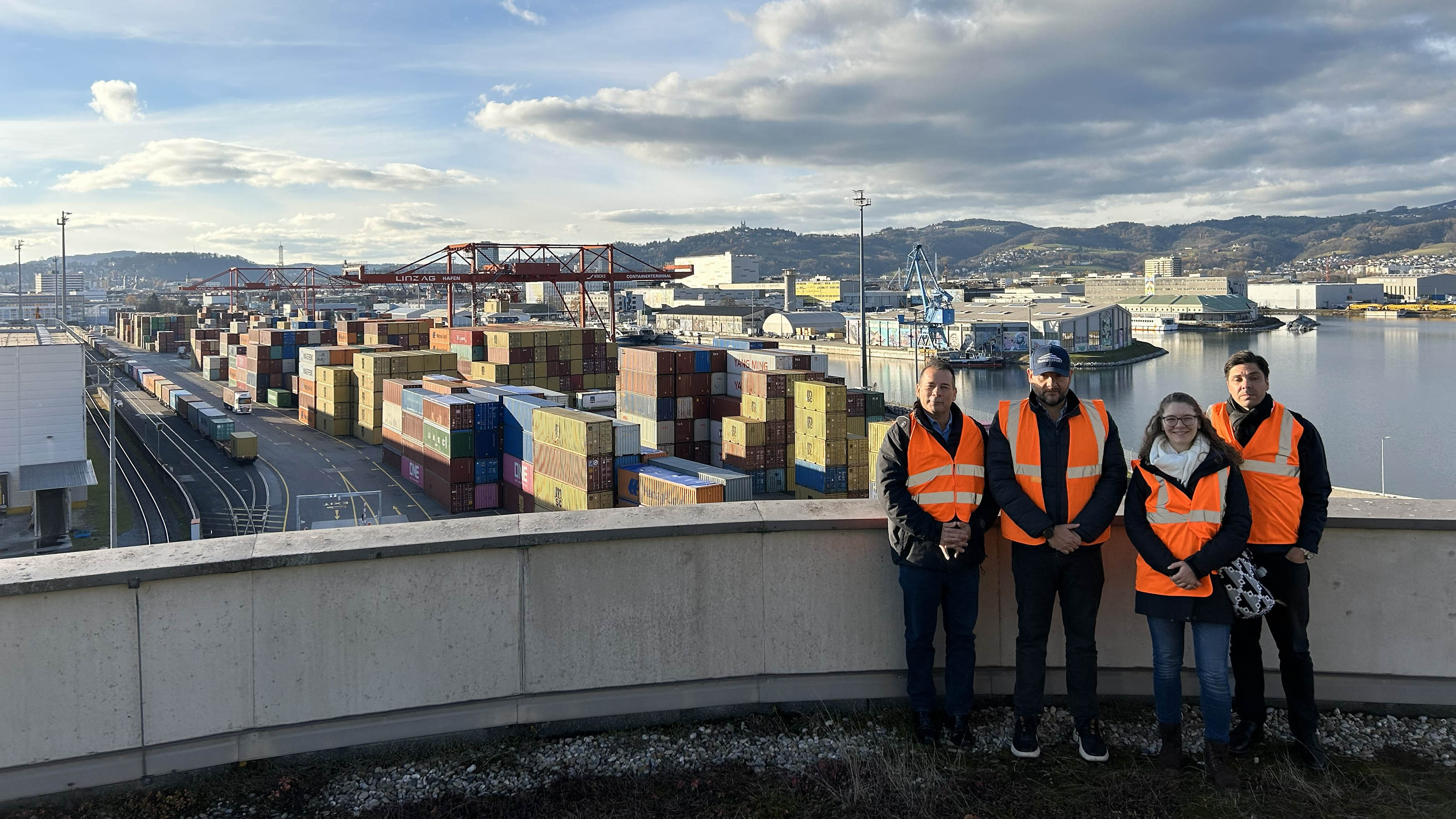 Vier Personen vor einem gro&szlig;en Hafengel&auml;nde
