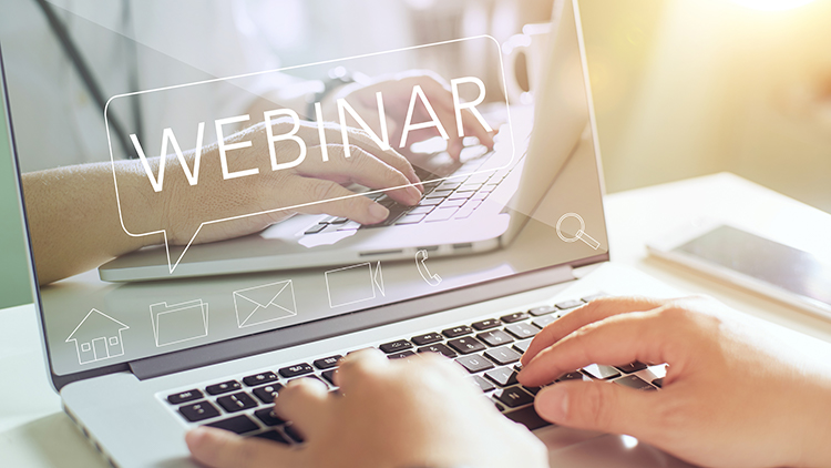 Hände auf Laptop tippend, am Screen der Schriftzug Webinar