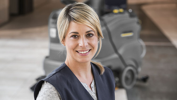 junge Frau vor Kärcher-Maschinen