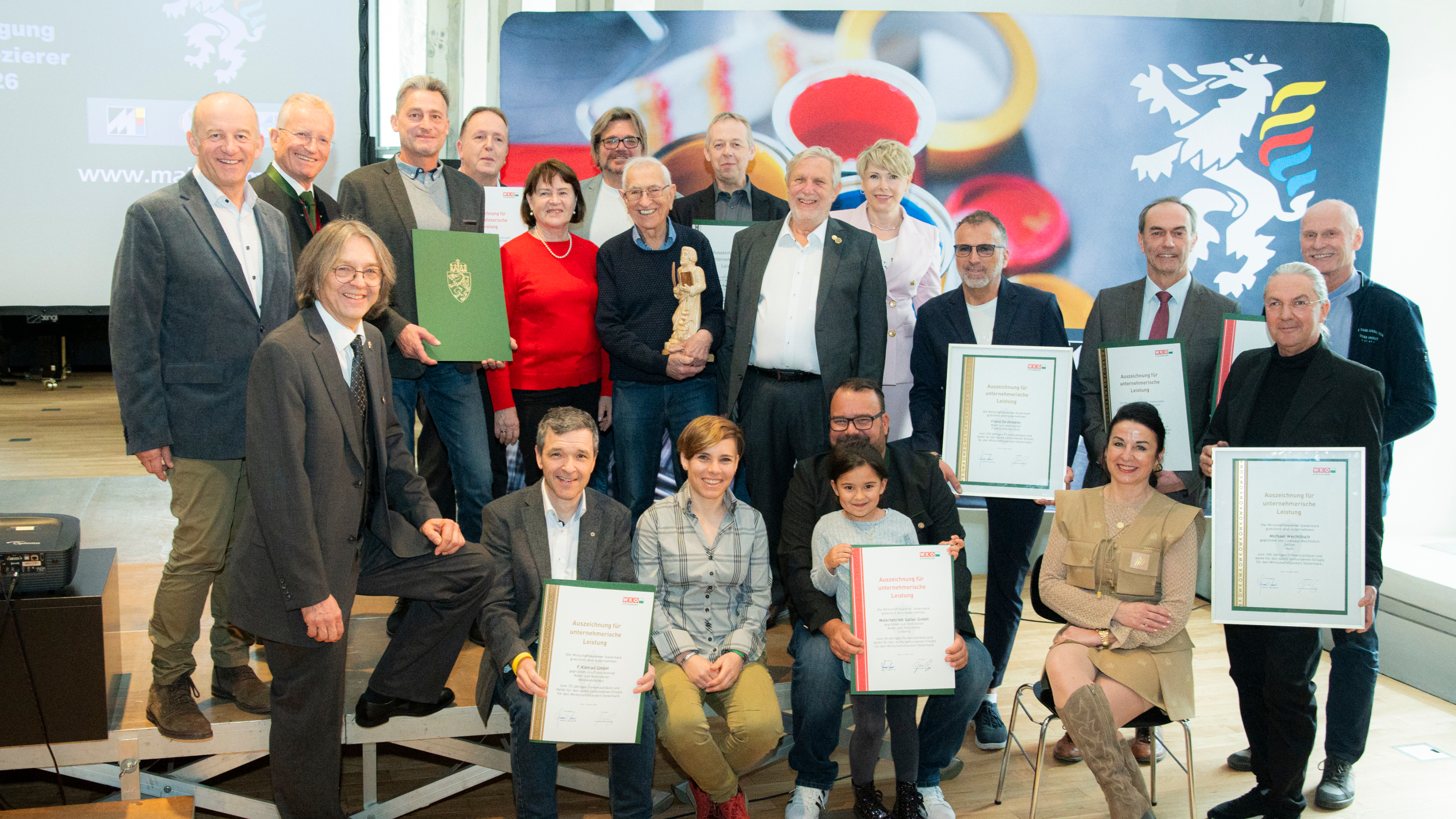 eine Gruppe von Personen posiert f&uuml;r das Foto und ein Teil h&auml;lt Urkunden in den H&auml;nden