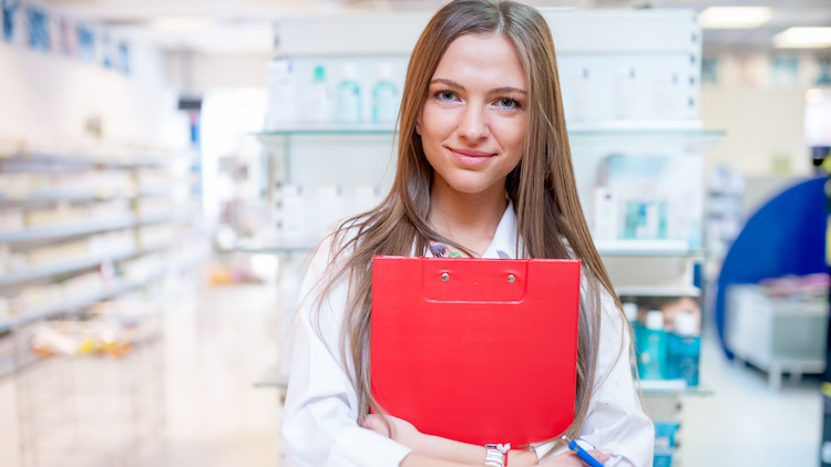 Junges Mädchen mit Block vor Drogerie-Kästen