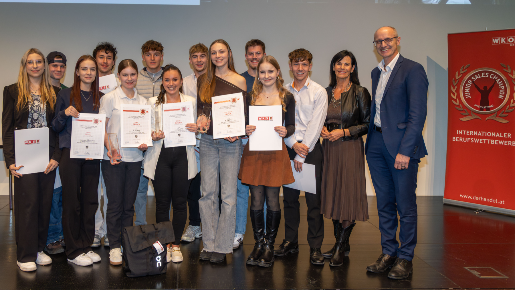 Gruppenfoto von Jugendlichen mit Urkunden in der Hand auf einer Bühne