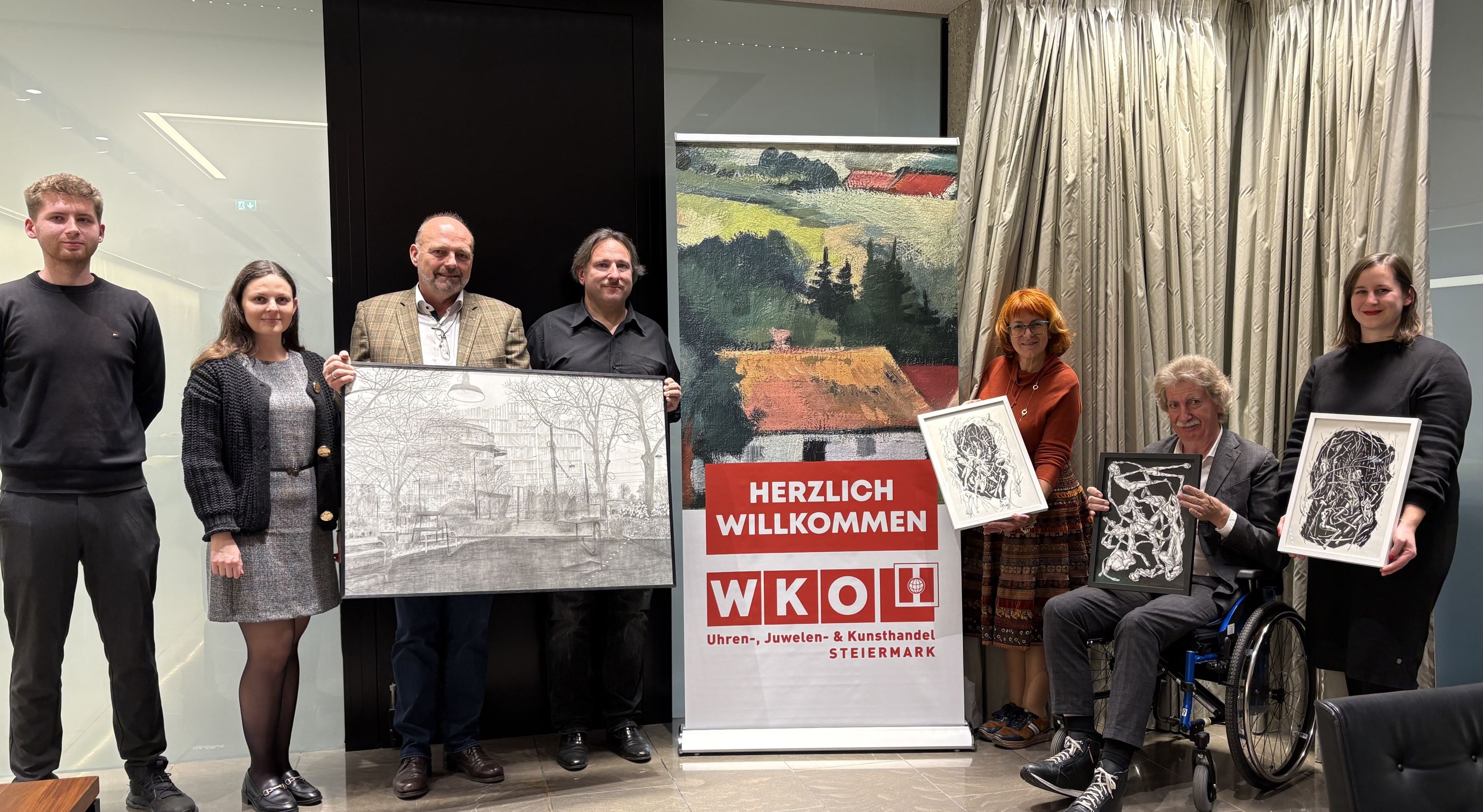 Menschen stehen neben einem Roll UP, dabei werden mehrere Kunstwerke pr&auml;sentiert