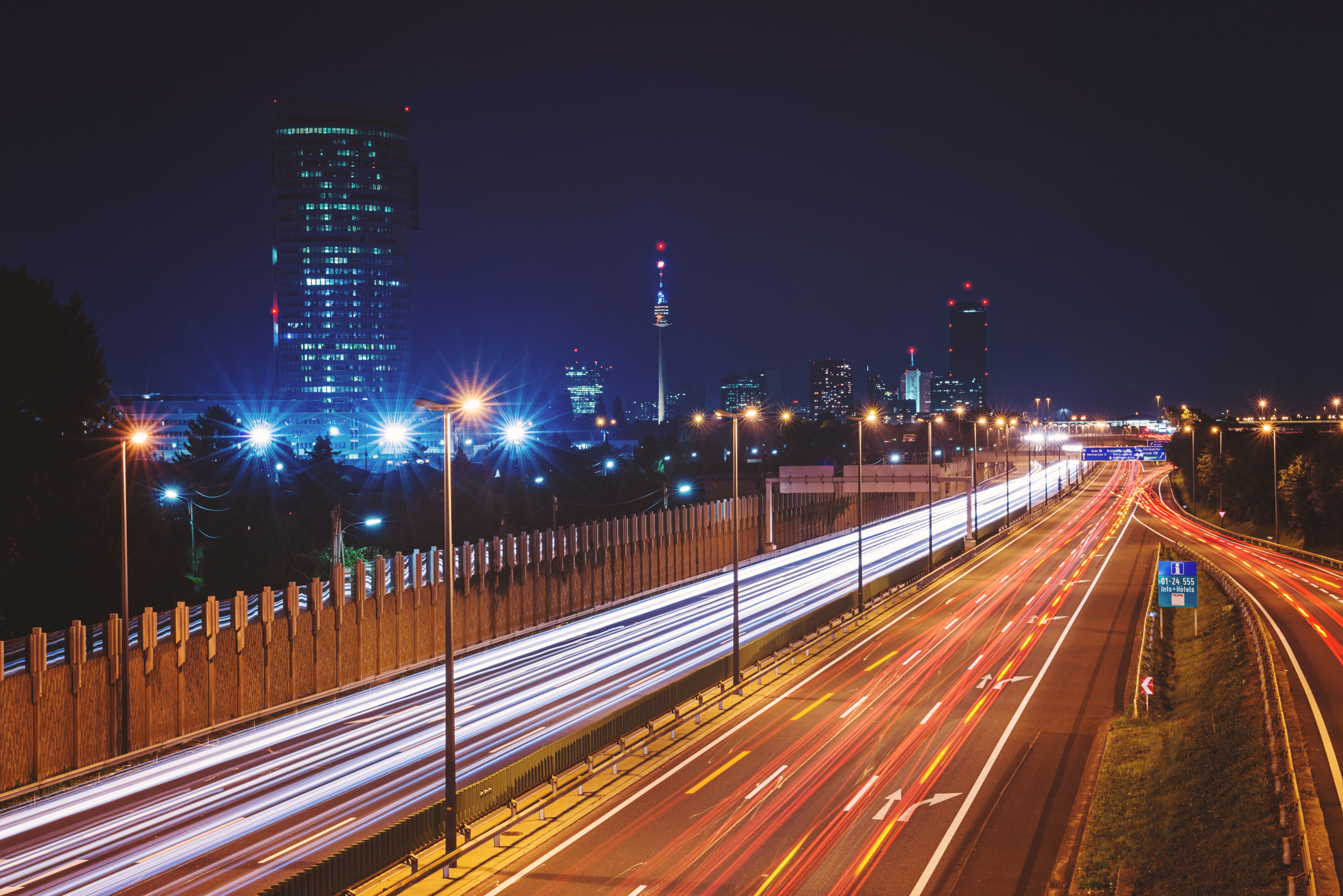 Langzeitbelichtung in der Nacht auf einer Autobahn in Wien: Rote und weiße leuchtenden Linien auf den Straßen.