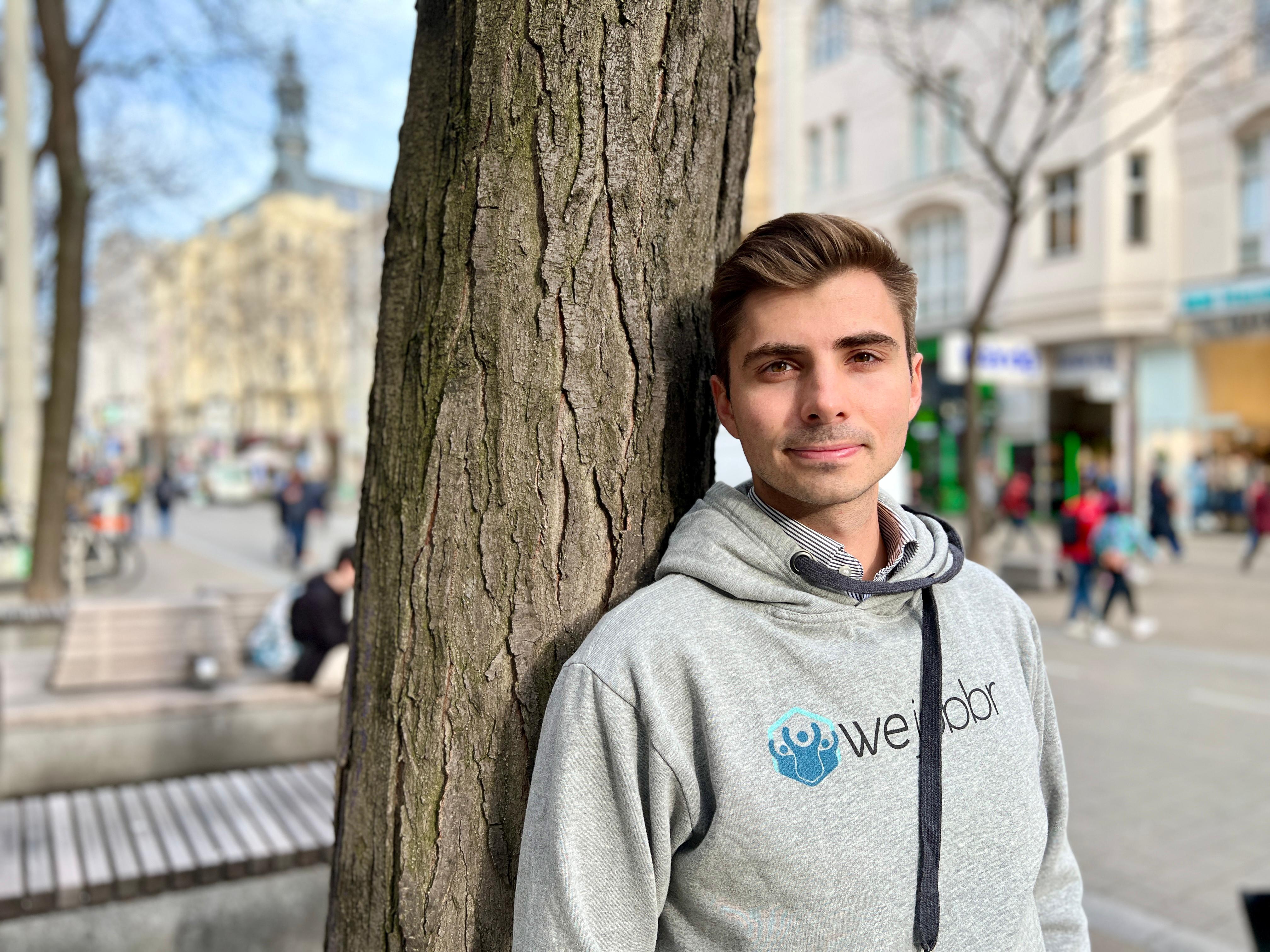 Voraberger vor einem Baum in grauem Pulli