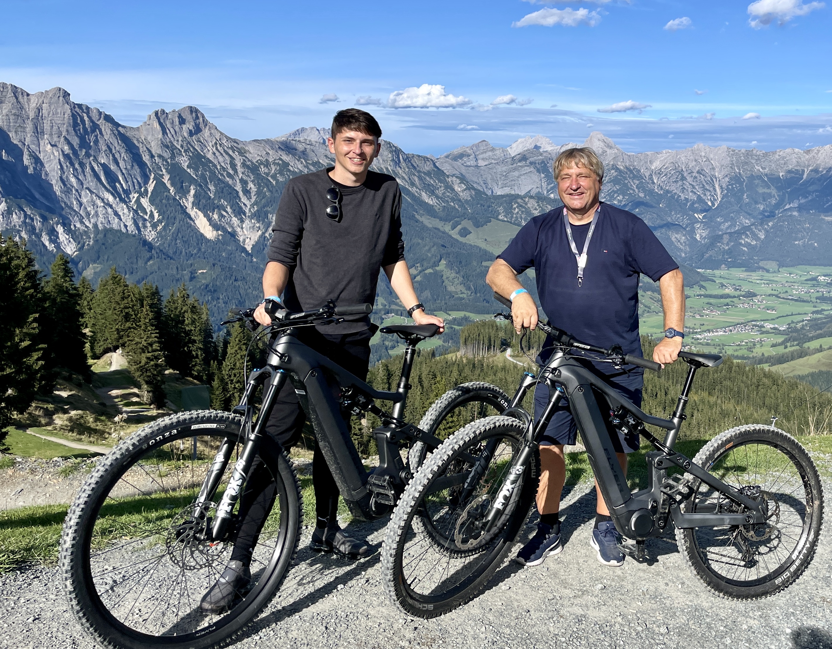 Nico und Gerhard Bauer mit E-Bikes vor sch&ouml;ner Gebirgslandschaft