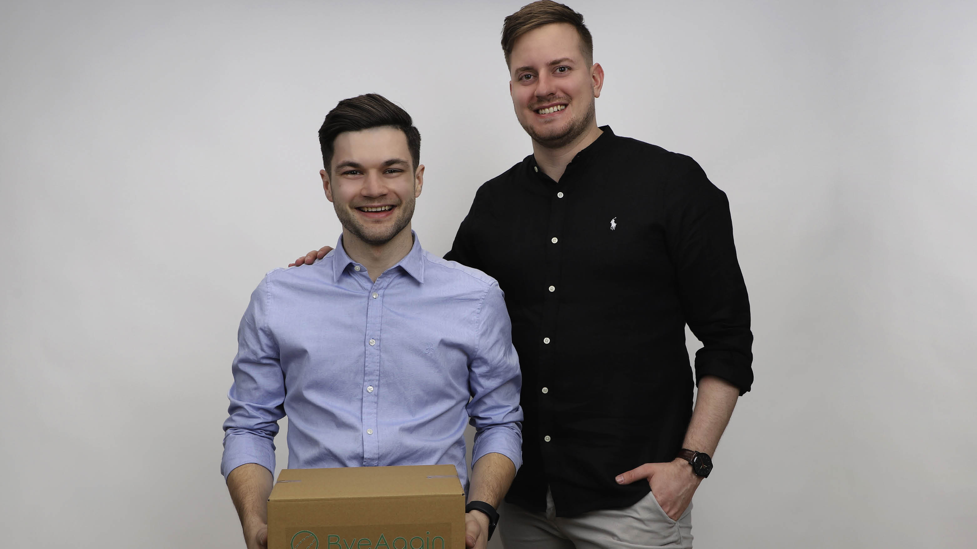 Die beiden Gr&uuml;nder mit einem braunen Paket in der Hand