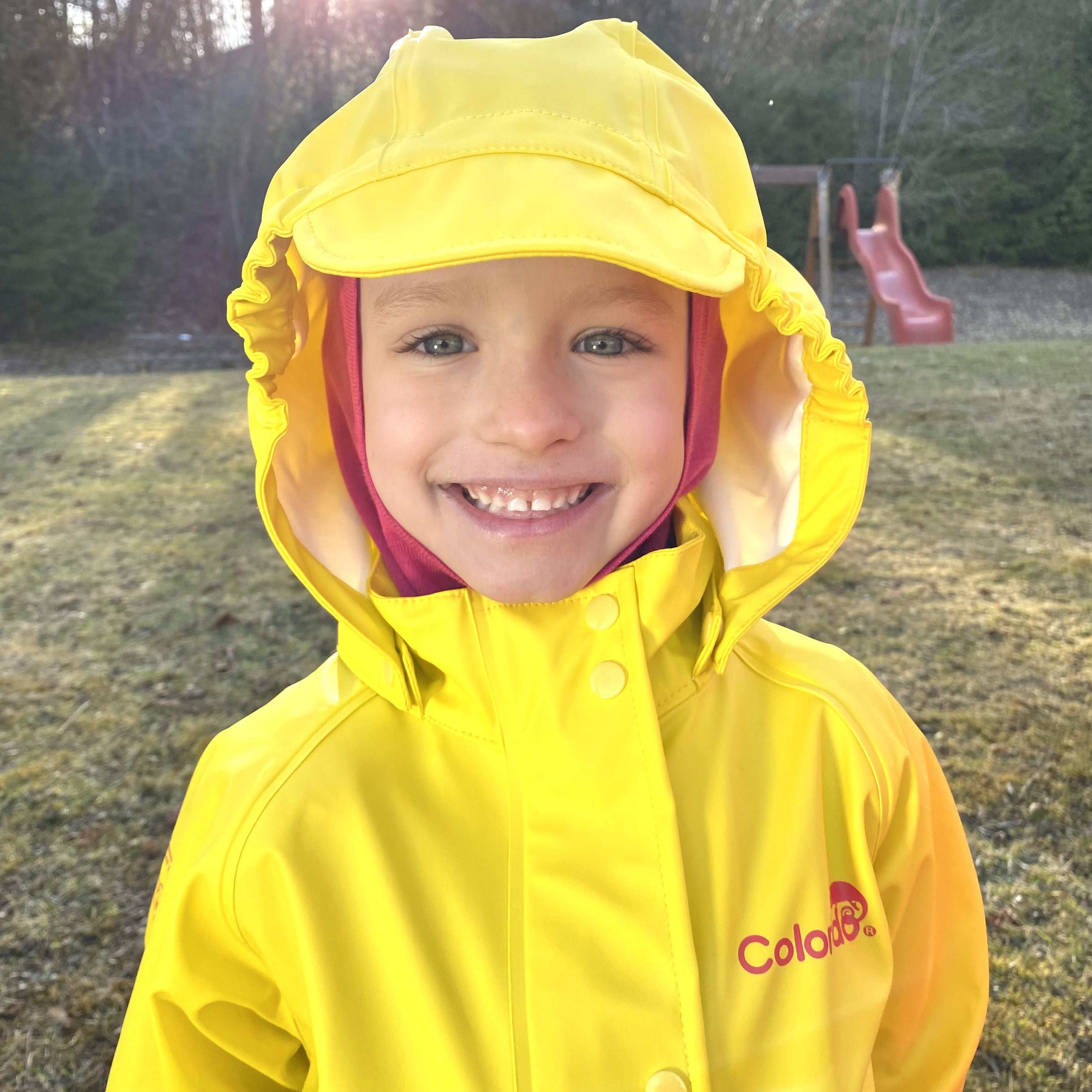 Ein Kind mit Regenschutzkleidung der Marke Colorido