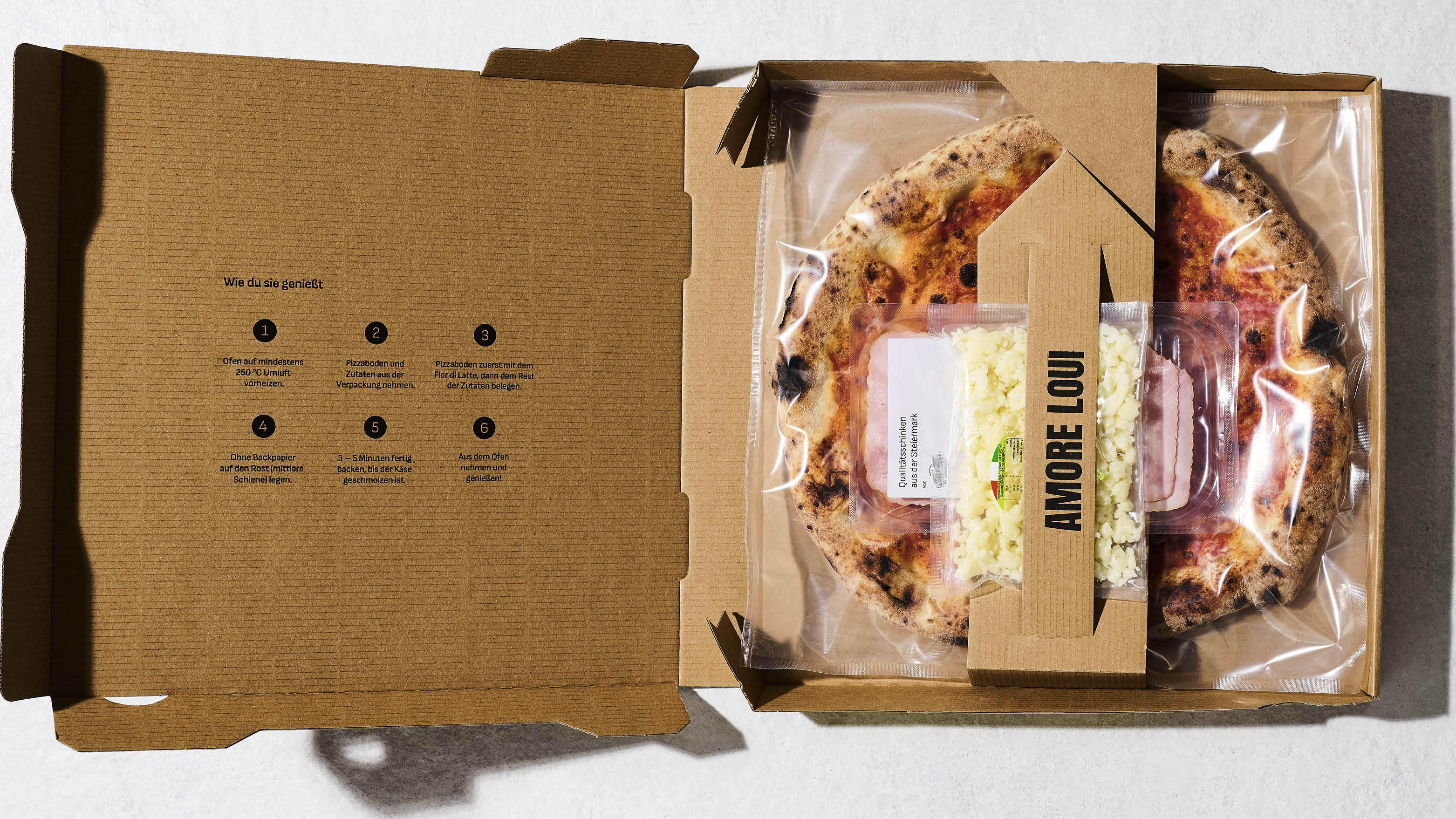 Pizza, gekühlt und vakuumiert im Karton mit Zutaten extra verpackt darauf