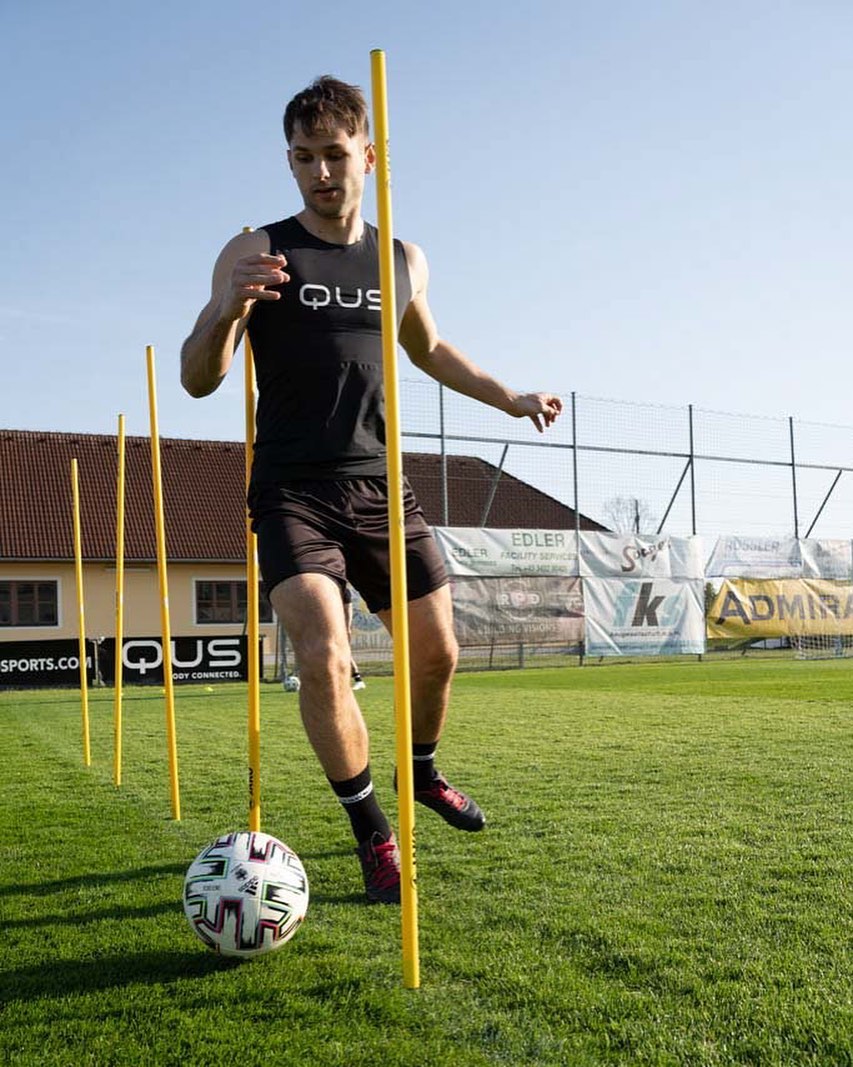 Fu&szlig;baller trainiert. Dabei hat er ein QUS T-shirt an.