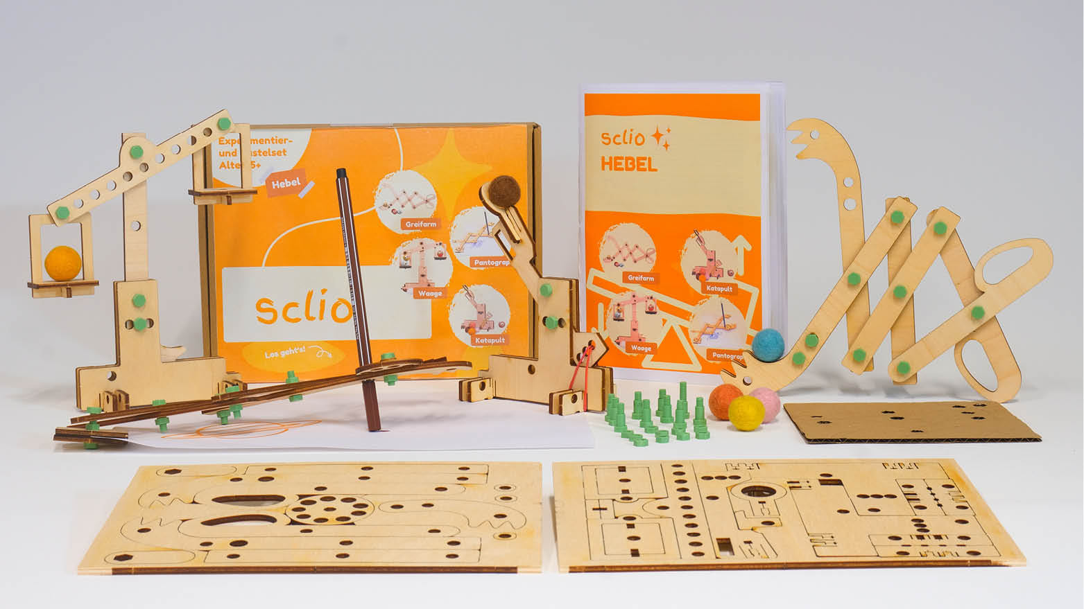 Blick auf die Hebel-Box mit ihren Inhalten, z.B. ein Holzkatapult und ein B&uuml;chlein