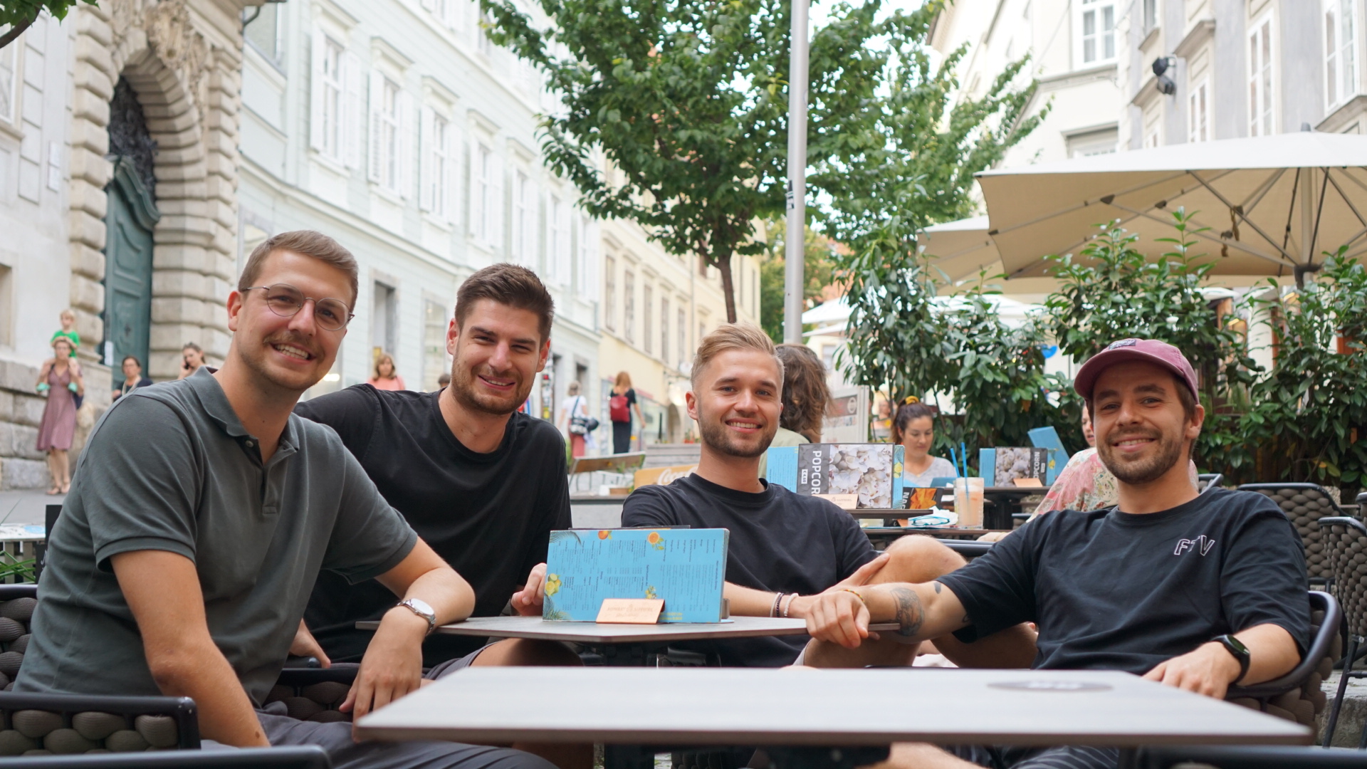 Die vier Gr&uuml;nder sitzen in einem Gastgarten