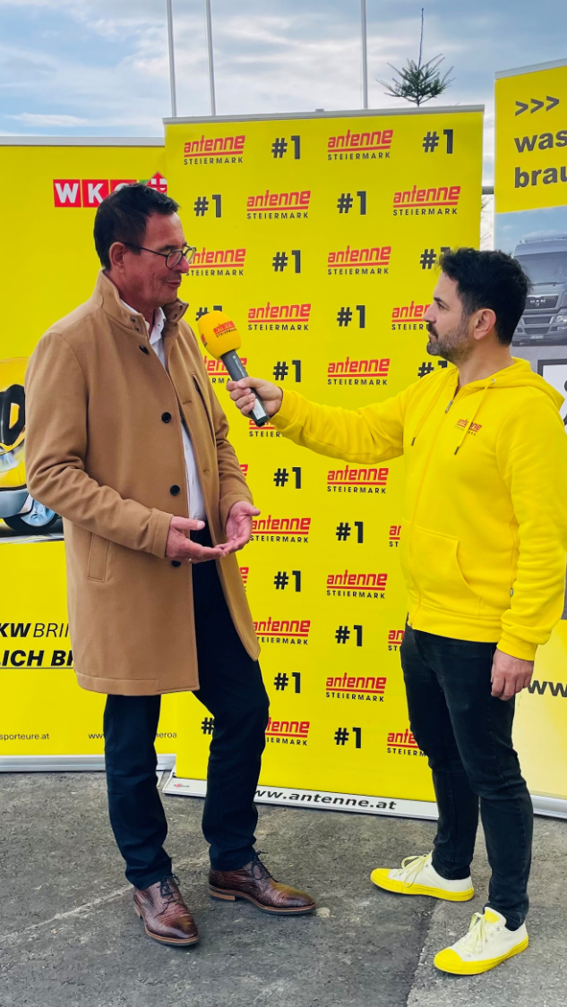 Antenne Steiermark Interviewer befragt Mann in beigem Mantel