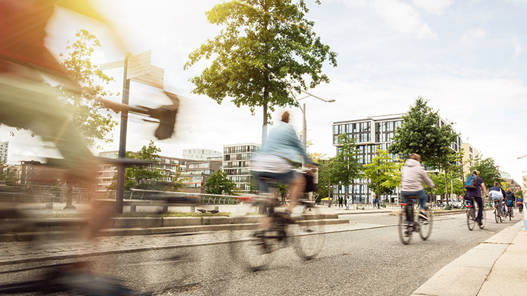 In Stadtgebiet radfahrende Personen in Bewegungsunsch&auml;rfe