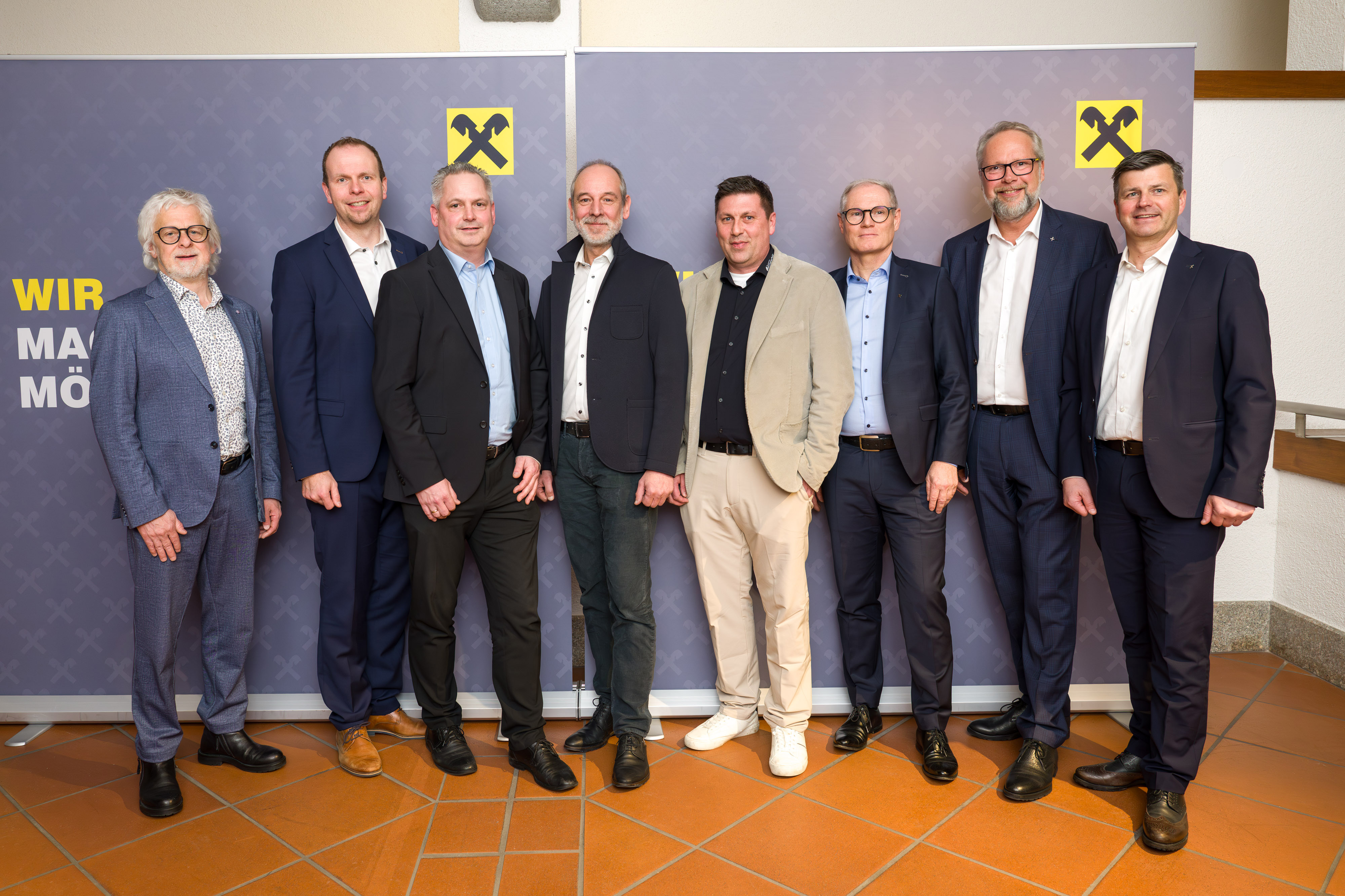 Gruppenfoto von acht Personen in Businesskleidung vor zwei Raiffeisen-Rollups im Veranstaltungssaal der Wirtschaftskammer Reutte, aufgenommen im Rahmen eines Informationsabends zum Thema Cybercrime.