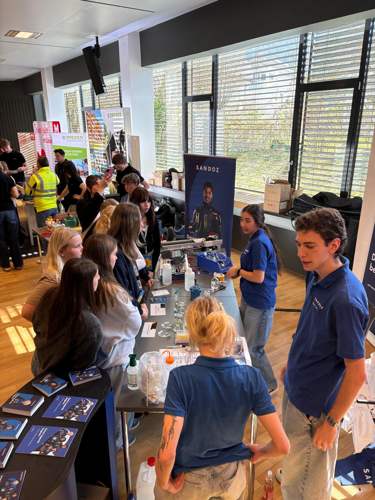 Jugendliche informieren sich an einem Stand &uuml;ber technische T&auml;tigkeiten und Lehrberufe, betreut von Aussteller:innen beim Berufsfestival Kufstein.