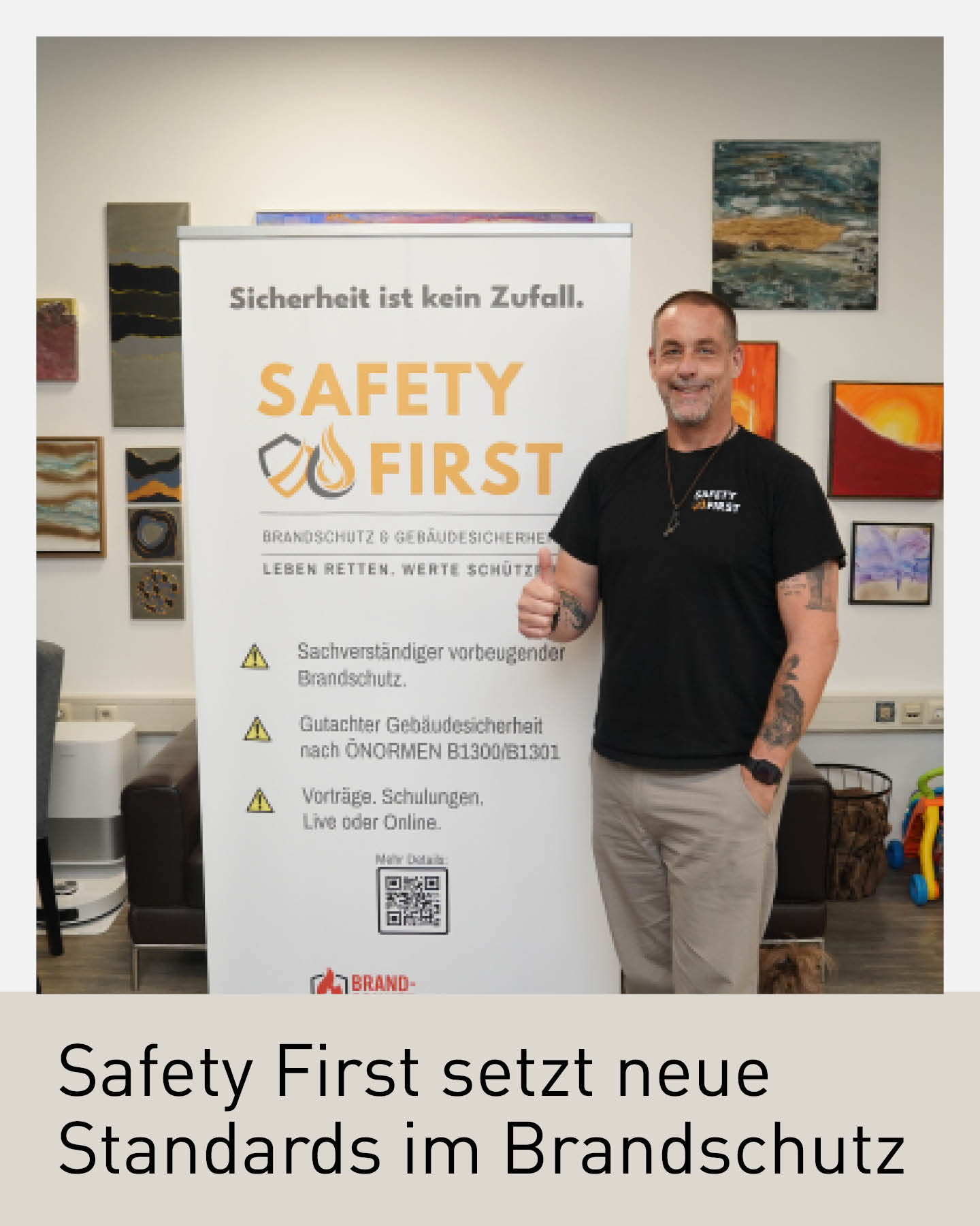 Mann vor Safety-First-Brandschutz-Rollup in einem Büro, Daumen hoch, Hinweis auf professionelle Brandschutz- und Gebäudesicherheitsleistungen.