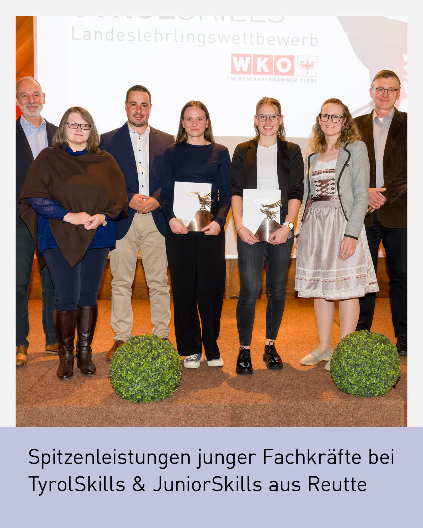 „Gruppenfoto der ausgezeichneten jungen Fachkräfte aus dem Bezirk Reutte bei den TyrolSkills und JuniorSkills. Die Lehrlinge stehen gemeinsam mit Vertreterinnen und Vertretern der Wirtschaftskammer Tirol auf einer Bühne und halten ihre Urkunden in den Händen.“