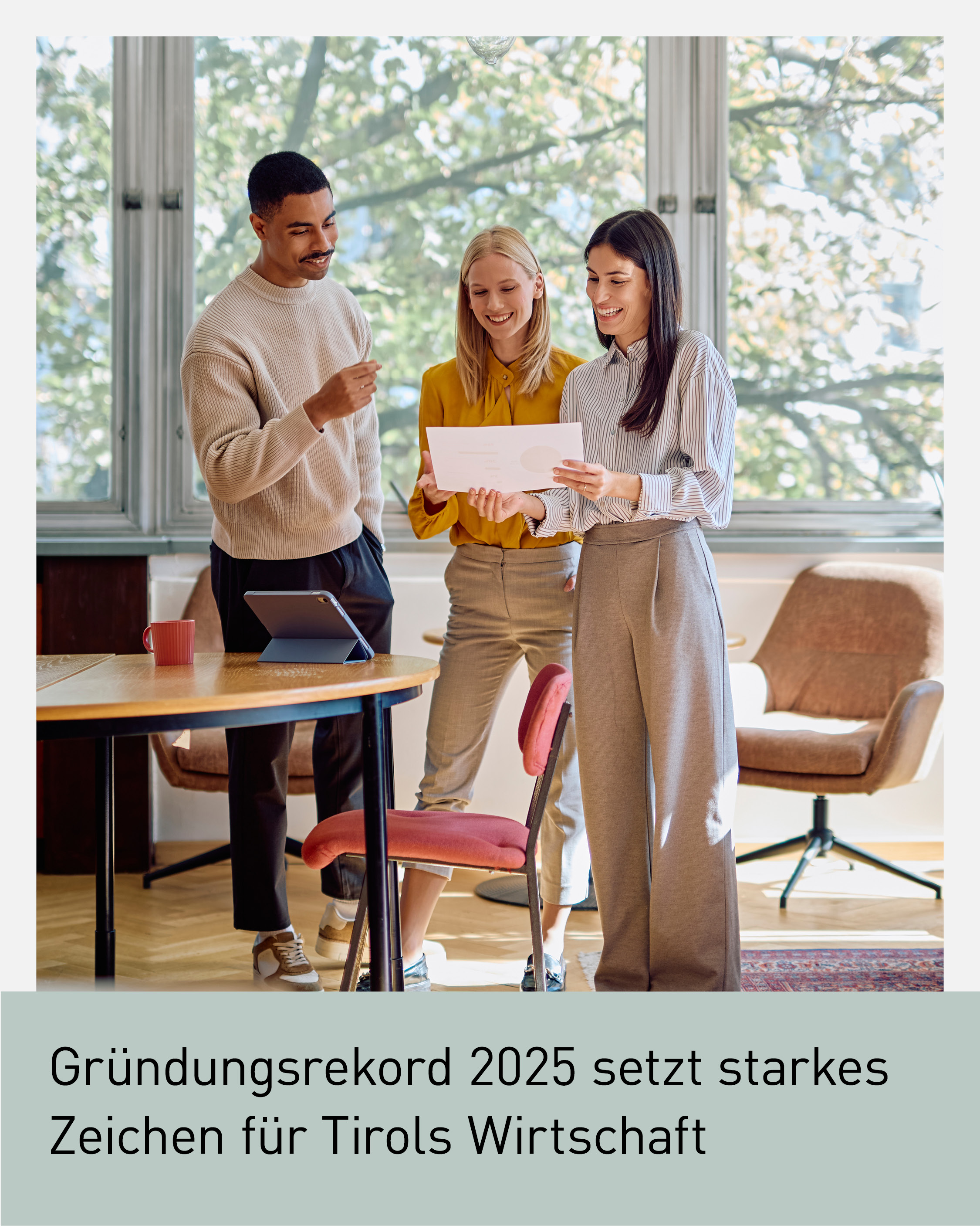 Drei junge Gr&uuml;nder:innen stehen in einem modernen B&uuml;ro und besprechen gemeinsam ein Dokument. Das Bild steht f&uuml;r Unternehmensgr&uuml;ndung, Beratung und Unternehmergeist in Tirol. Visual zum Thema Gr&uuml;ndungsrekord 2025, Wirtschaftsstandort Tirol und Services der Wirtschaftskammer Tirol f&uuml;r Gr&uuml;nder:innen