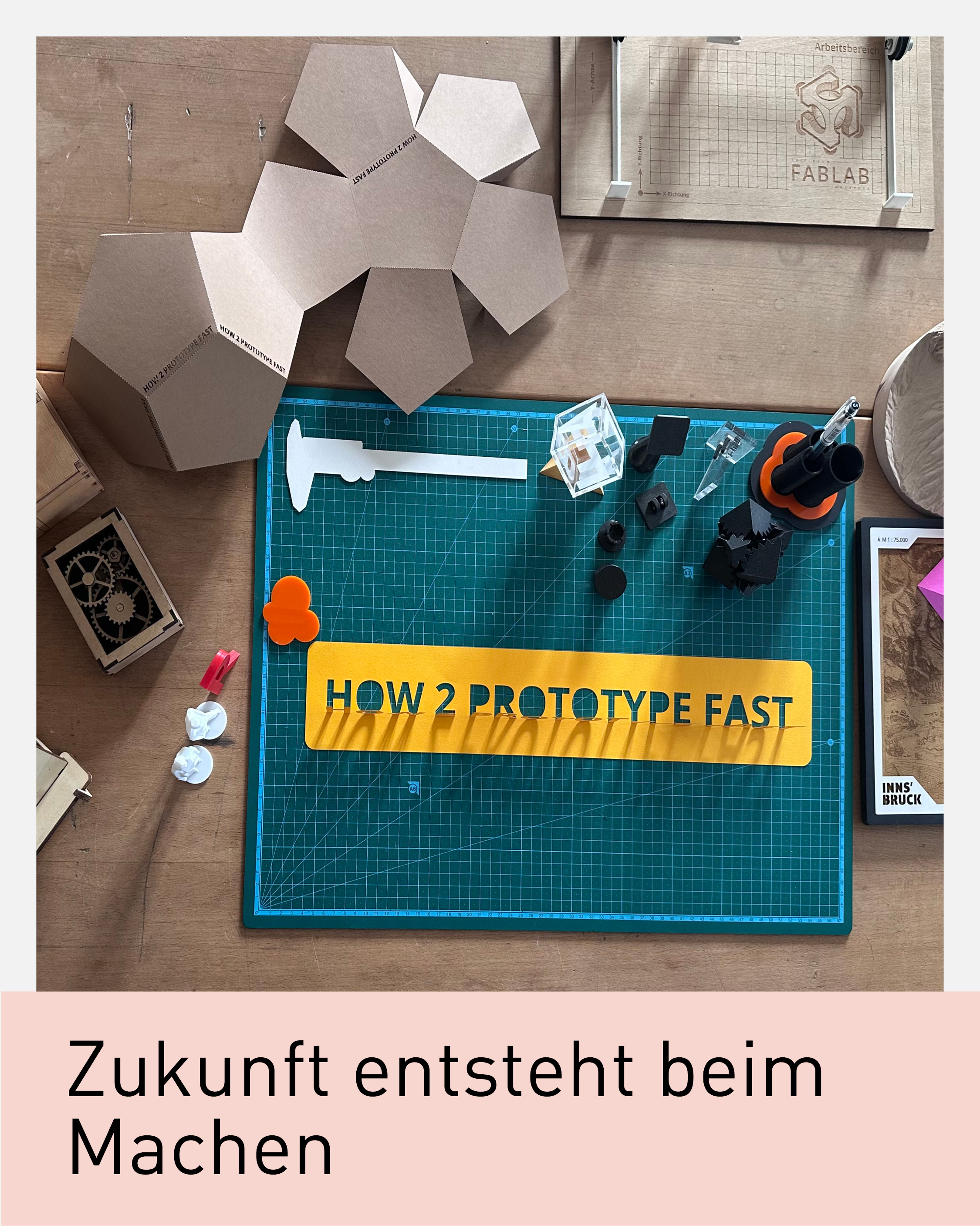 Arbeitsplatz im InnCubator mit Schneidematte, Werkzeugen sowie Prototypen aus Karton, Holz und 3D-Druck. Das Sujet „Zukunft entsteht beim Machen“ steht für Innovation, schnelles Prototyping und Weiterbildung der Universität Innsbruck und Wirtschaftskammer Tirol.