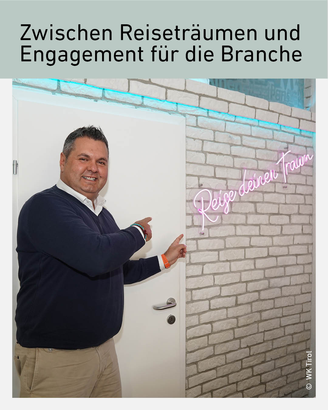 Bora Eker, Gesch&auml;ftsf&uuml;hrer des Reiseb&uuml;ros Efereisen in Telfs und Funktion&auml;r der Wirtschaftskammer Tirol, steht in seinen Gesch&auml;ftsr&auml;umlichkeiten und zeigt auf einen Schriftzug mit der Aufschrift &bdquo;Reise deinen Traum&ldquo;