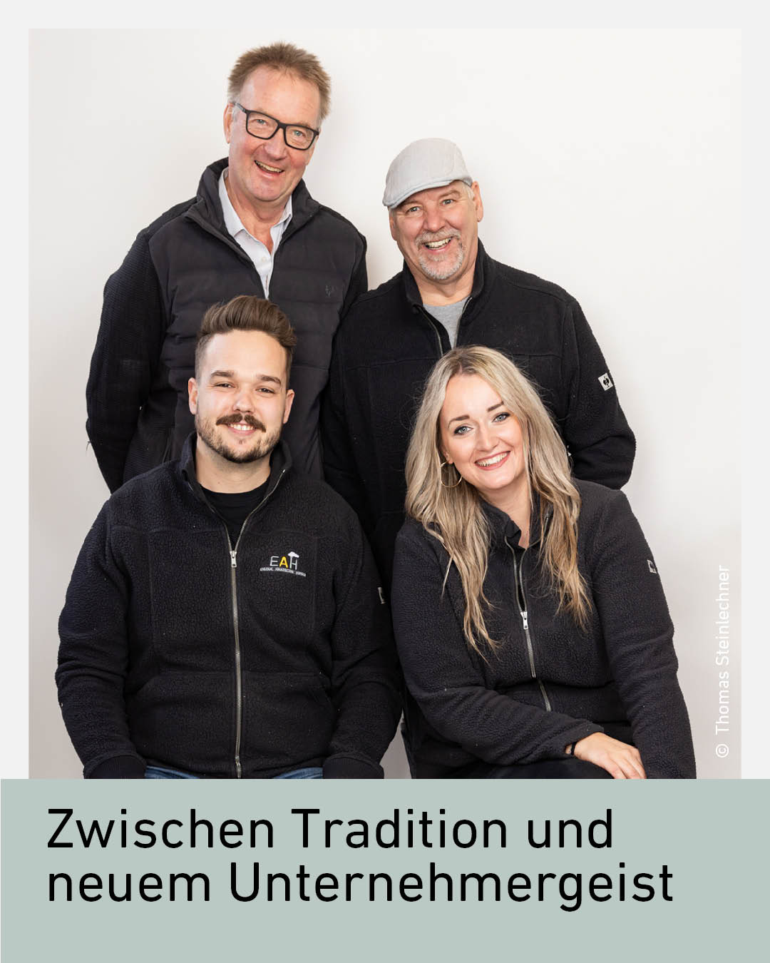 Vier Mitglieder des Familienbetriebs EAH Hupfauf posieren gemeinsam vor hellem Hintergrund. Vorne sitzen beziehungsweise stehen Lukas Steiner und Lisa Hupfauf, dahinter zwei &auml;ltere M&auml;nner aus dem Familien- und Betriebsumfeld. Alle l&auml;cheln freundlich und tragen dunkle Kleidung beziehungsweise Firmenjacken.