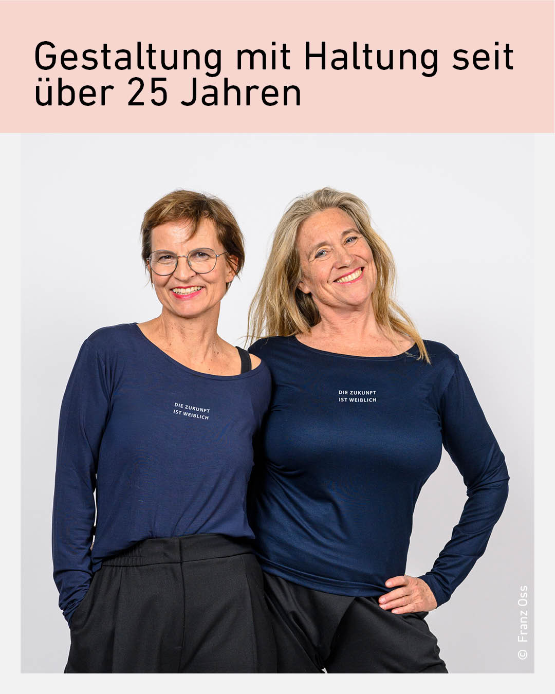 Zwei Frauen mittleren Alters mit nah beieinander stehenden Oberk&ouml;rpern und Aufschriften "Die zukunft ist weiblich" auf ihren Shirts.