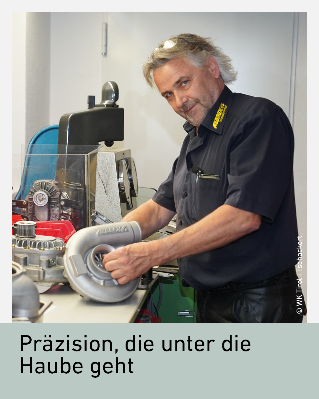Ein Mann in einem Werkstattumfeld bearbeitet einen Turbolader an einer Werkbank.