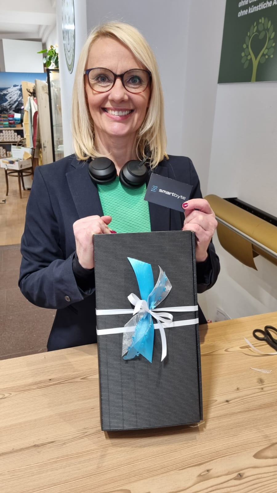 Person posiert mit einem sch&ouml;n eingepackten Geschenk