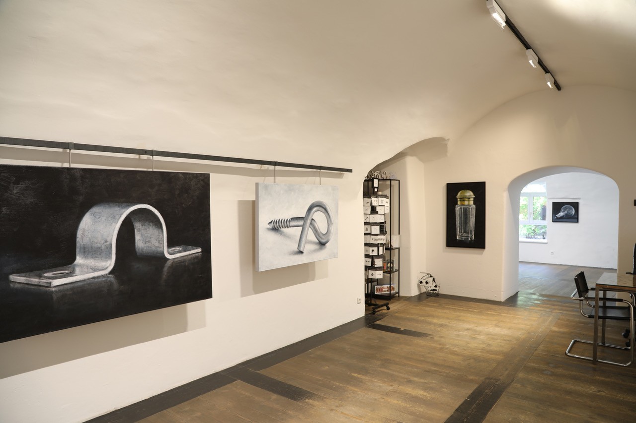 Blick in einen Ausstellungsraum des artdepot. An den wei&szlig;en W&auml;nden h&auml;ngen gro&szlig;formatige Gem&auml;lde, der Raum verf&uuml;gt &uuml;ber einen dunklen Holzboden und ein Tonnengew&ouml;lbe. Im Hintergrund f&uuml;hrt ein Rundbogen in einen weiteren Ausstellungsbereich.