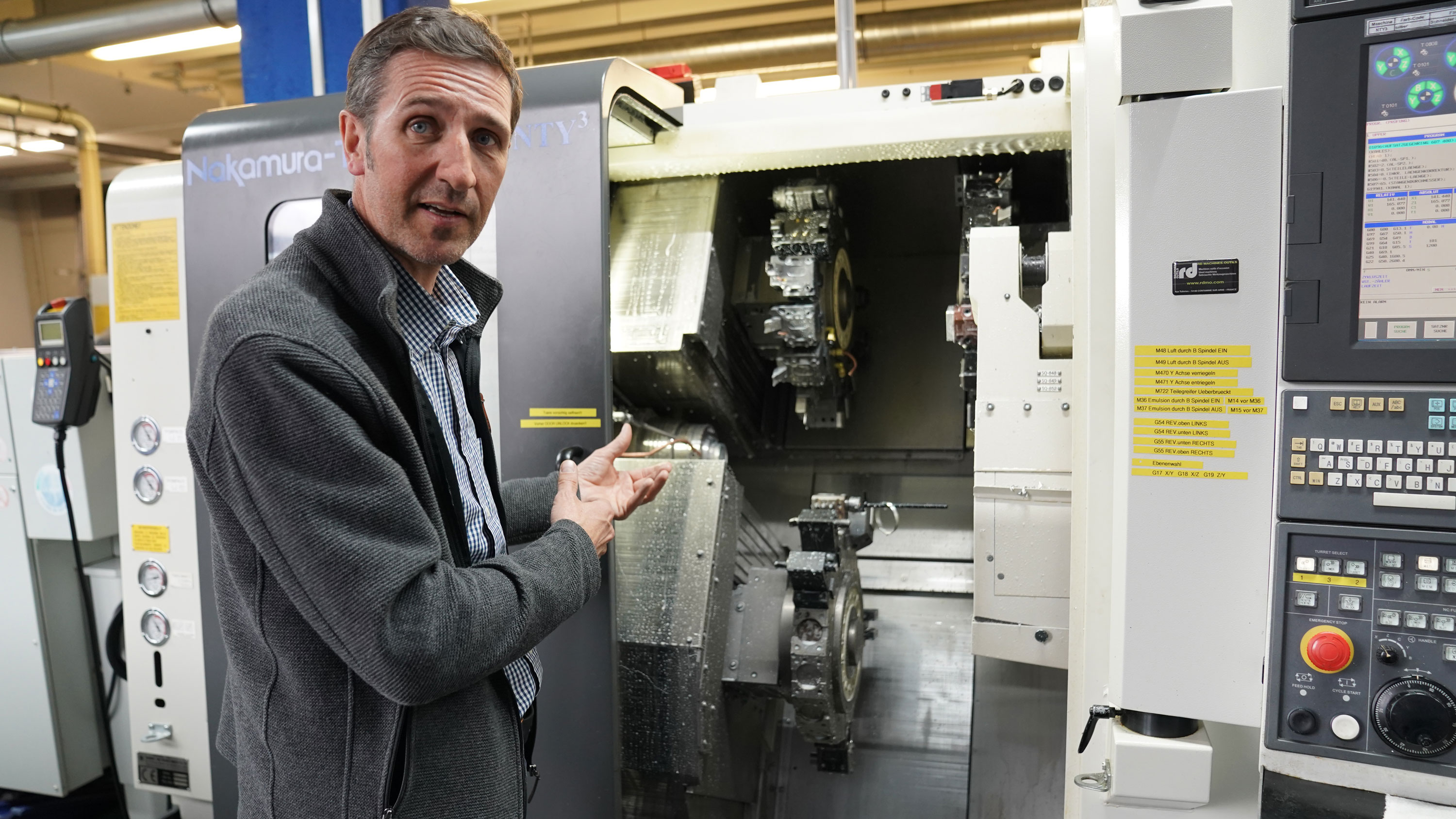 Der Geschäftsführer Hans Langesee erklärt seine leistungsstärkste CNC-Maschine. Durch sie sind Präzisionsarbeiten auf bis zu einen sechs- bis neuntausendstel Millimeter genau möglich.