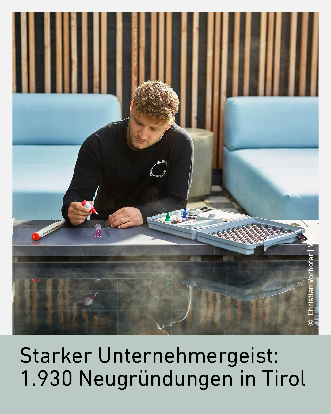Ein junger Mann sitzt an einem Tisch und arbeitet mit verschiedenen Werkzeugen und Materialien.