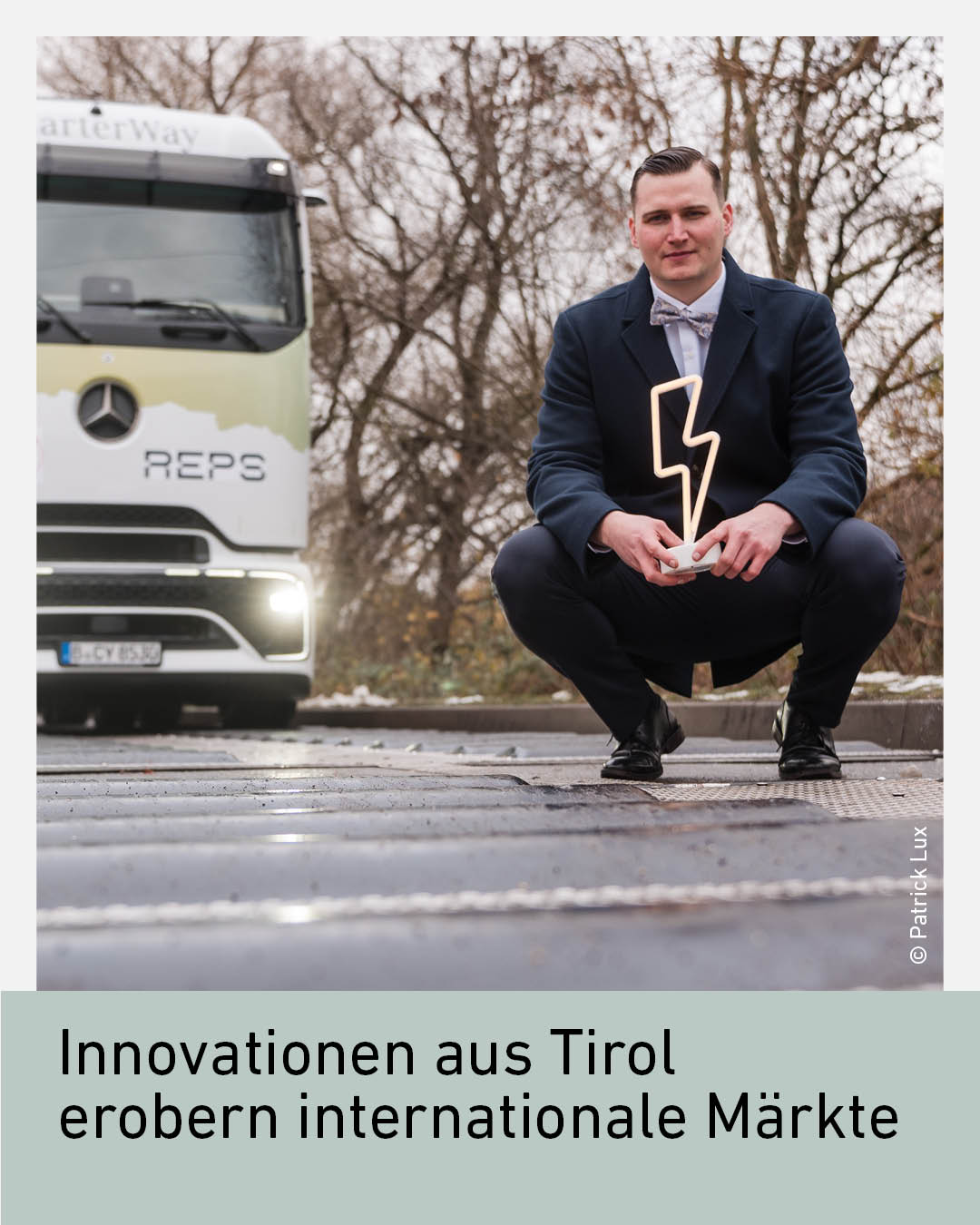 Tiroler Unternehmer pr&auml;sentiert Innovationsauszeichnung vor einem elektrischen Lkw. Bild steht f&uuml;r technologische Innovationen aus Tirol, nachhaltige Mobilit&auml;t, Elektromobilit&auml;t und den erfolgreichen Markteintritt auf internationalen M&auml;rkten
