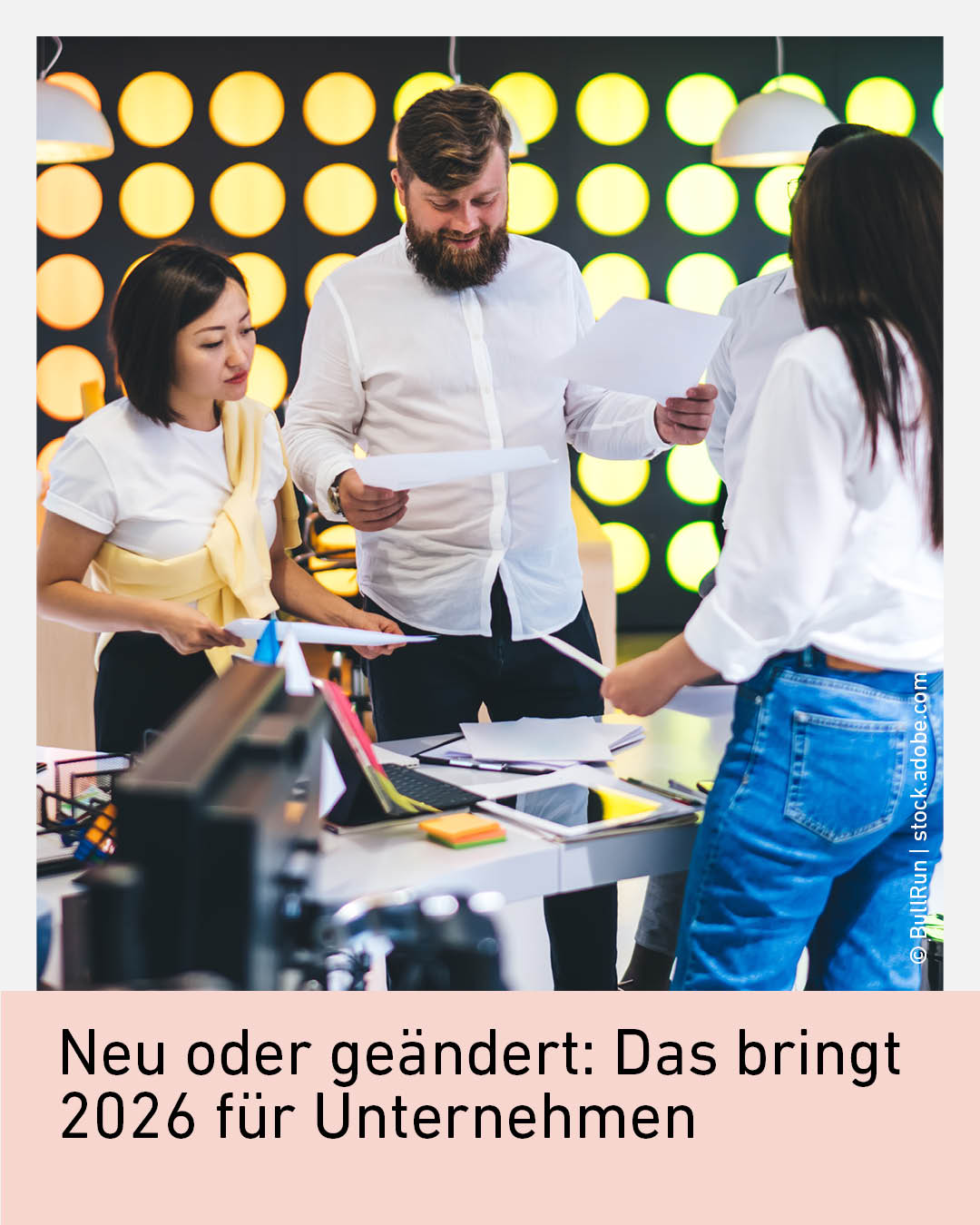 Eine Gruppe von Personen im B&uuml;ro diskutiert und arbeitet zusammen an Dokumenten und Ger&auml;ten.