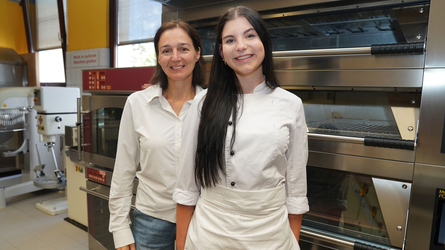 Starkes Team in der Ausbildung. Konditor Lehrling Sophia Höllwarth im Gespräch mit ihrer Ausbilderin Daniela Freudenschuß. Die beiden teilen nicht nur die Begeisterung für kreative Konditorkunst, sondern auch das Verständnis dafür, wie wichtig eine praxisnahe und wertschätzende Lehrlingsausbildung für die Zukunft des Handwerks ist. 