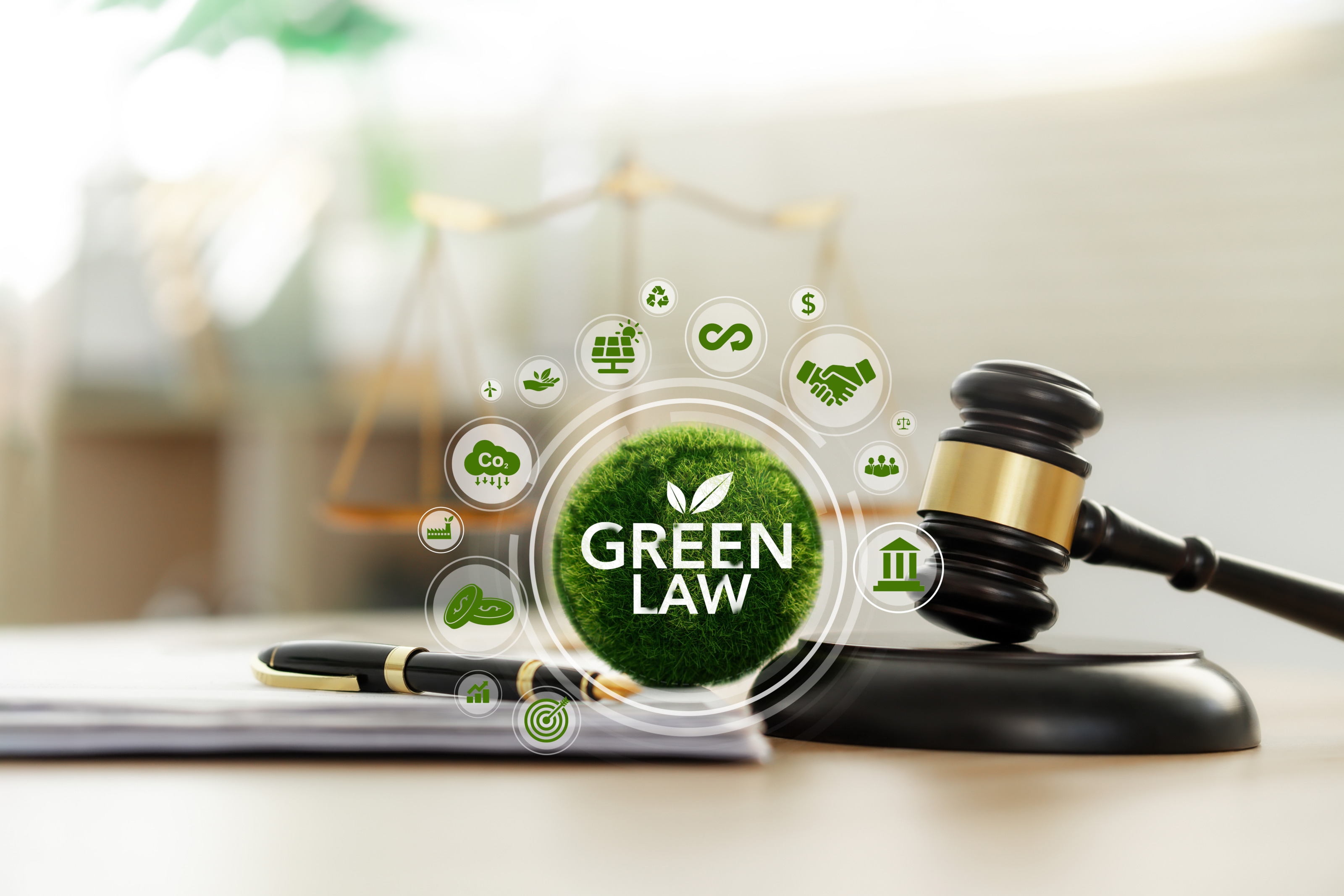 Braungoldener Richterhammer neben Grasball mit Beschriftung Green Law umgeben von verschiedenen kreisrund eingefassten gr&uuml;nen Grafiken wie Wolke mit Aufschrift CO2 und Pfeilen nach unten, Solarpaneel mit Sonne, M&uuml;nzen, Handschlag und Windrad