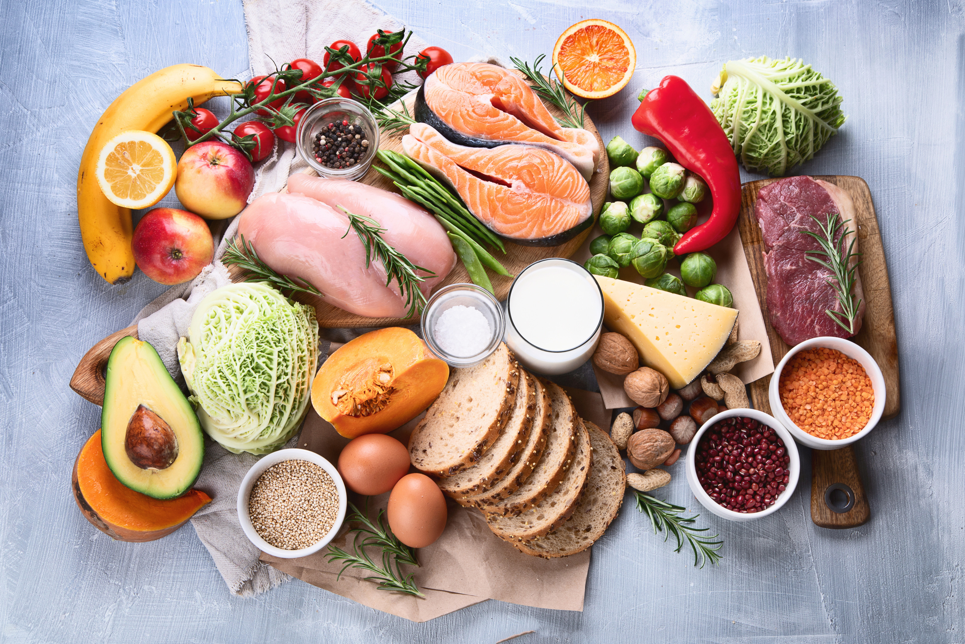 Verschiedene Lebensmittel arrangiert auf einem gestrichenen Untergrund