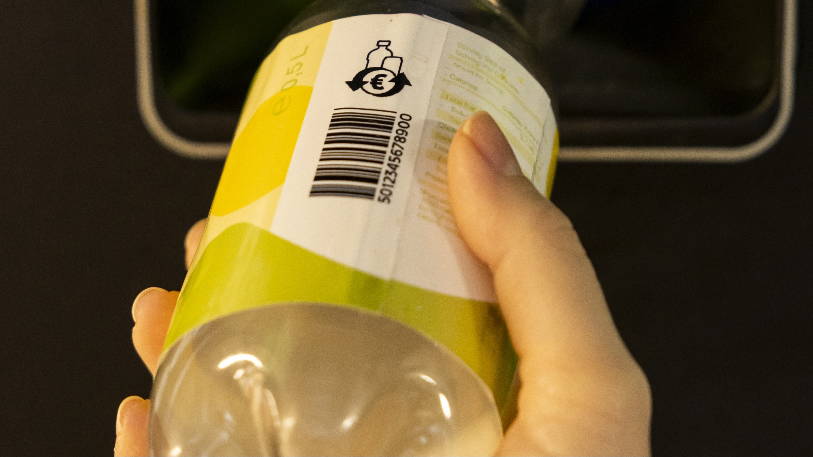 Plastik-Getr&auml;nkeflasche mit Pfand-Logo wird in R&uuml;ckgabe-Automat eingef&uuml;hrt